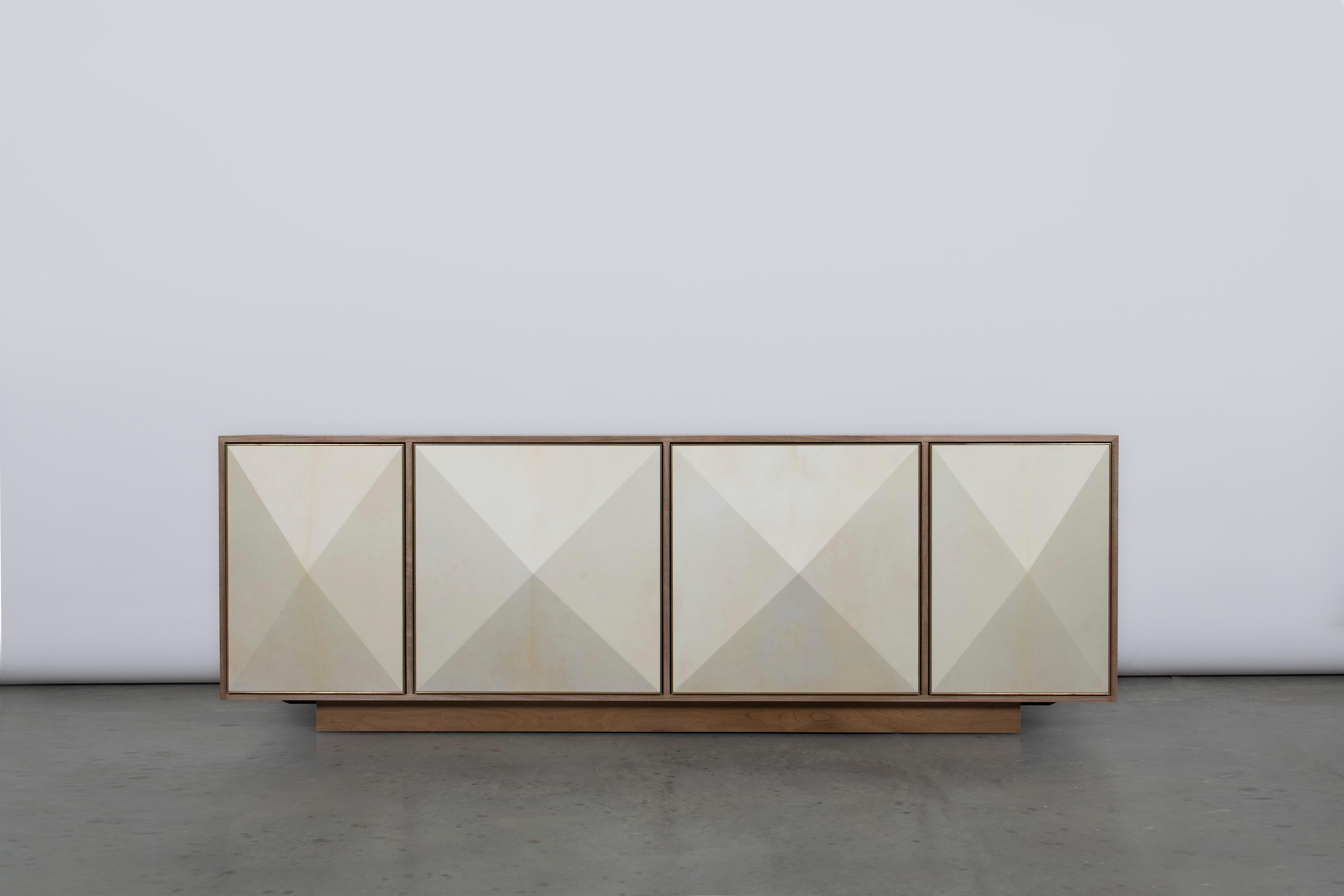 The Pyramid Sideboard features three-dimensional doors hand-wrapped in natural goatskin parchment and framed subtly in satin brass. A recessed base gives the piece a floating appearance.

Available in a variety of woods as well as different size