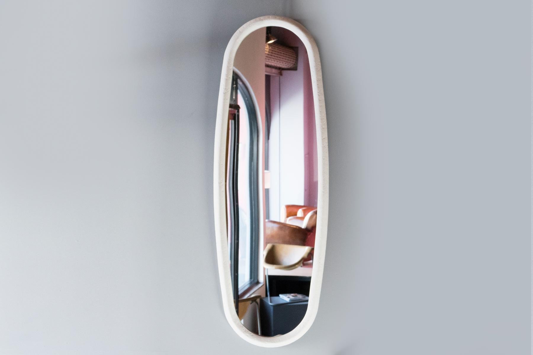 Handcrafted plaster of Paris mirror with a unique shape. Can be hung in either direction.