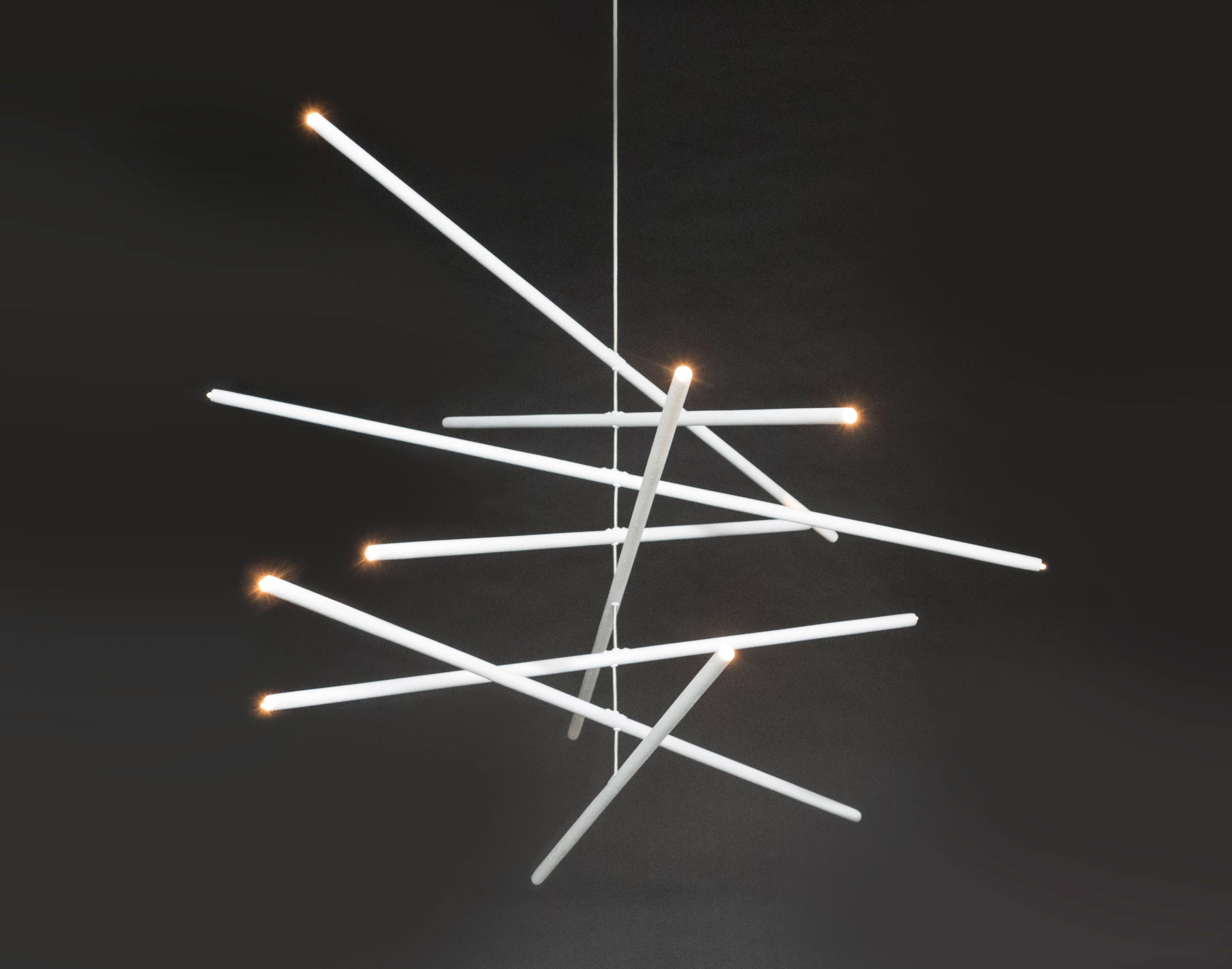 Presenta uno squisito lampadario che offre una miscela armoniosa di eleganza e innovazione. Le aste di gesso rifinite a mano sono sospese ad arte da fili di acciaio inossidabile intrecciati, creando un'illusione di mobilità fluttuante. Dotato di
