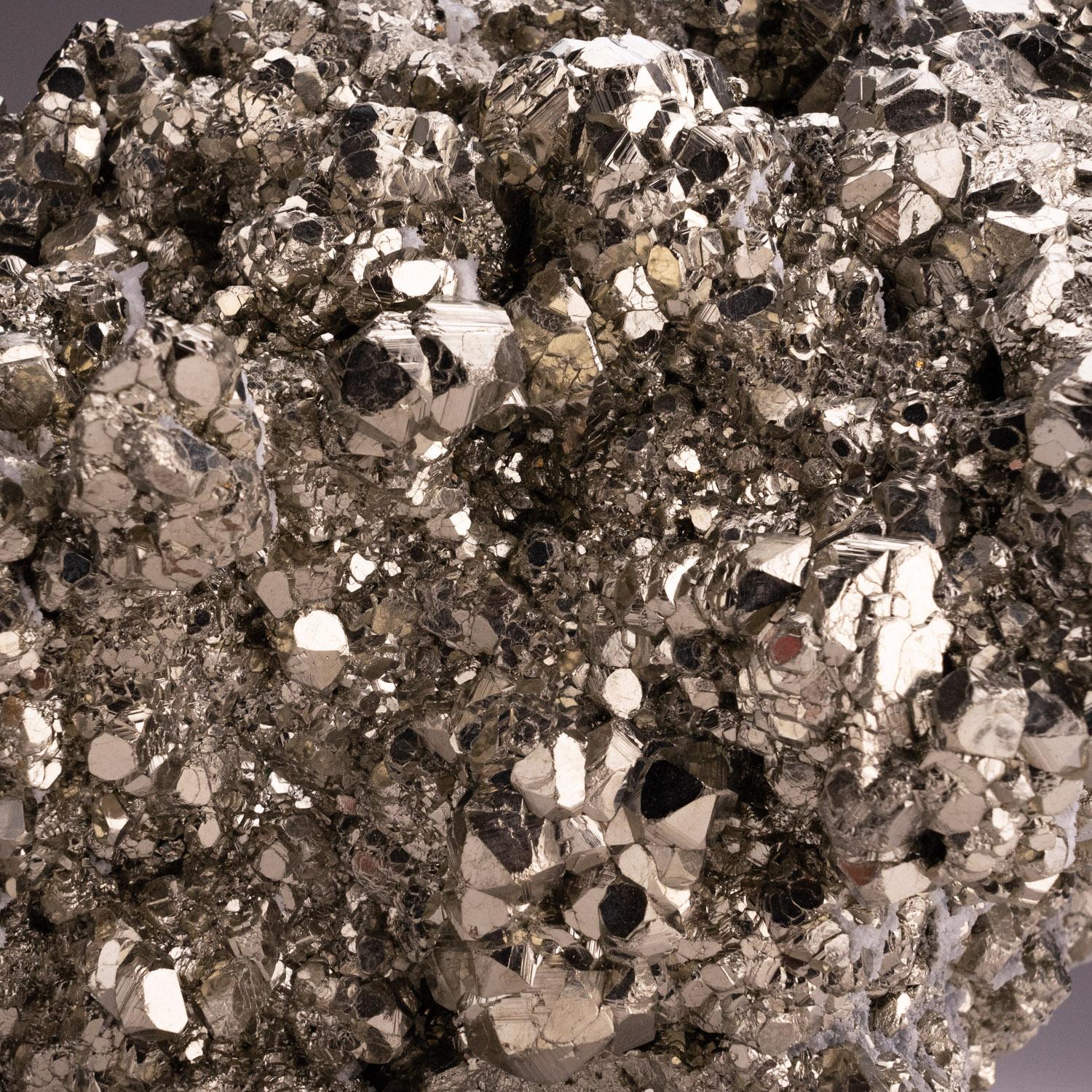 A classic and very attractive specimen of Pyrite from Huanzala Mine, Huanuco Province, Peru. Complex pyritohedron cluster with striated crystal faces and a metallic mirror luster with a bright golden color. There are several areas coated with