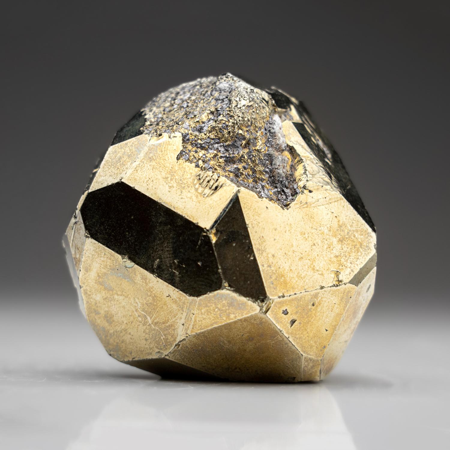 Lustrous yellow-metallic pyrite compound crystal with remnants of tan-colored matrix on the bottom. The pyrite crystal is cubo-octahedral form with striated cubic faces and layered parallel octahedral faces.

You will receive the exact object in