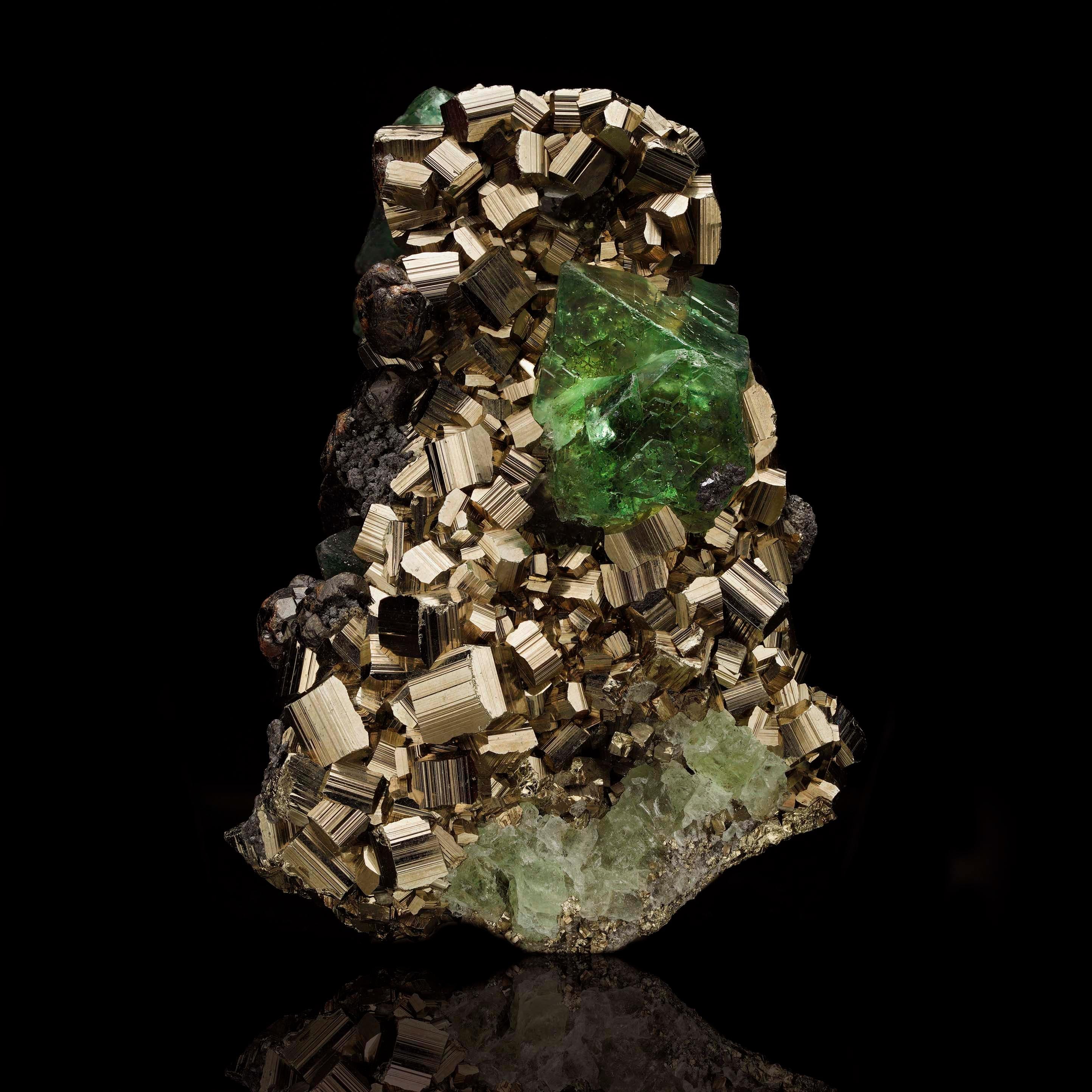 Questo straordinario esemplare di pirite con fluorite verde proveniente dal Perù è un'accattivante combinazione di brillantezza metallica e vibranti sfumature verdi. I cristalli cubici di pirite, ben formati, brillano di una lucentezza dorata,