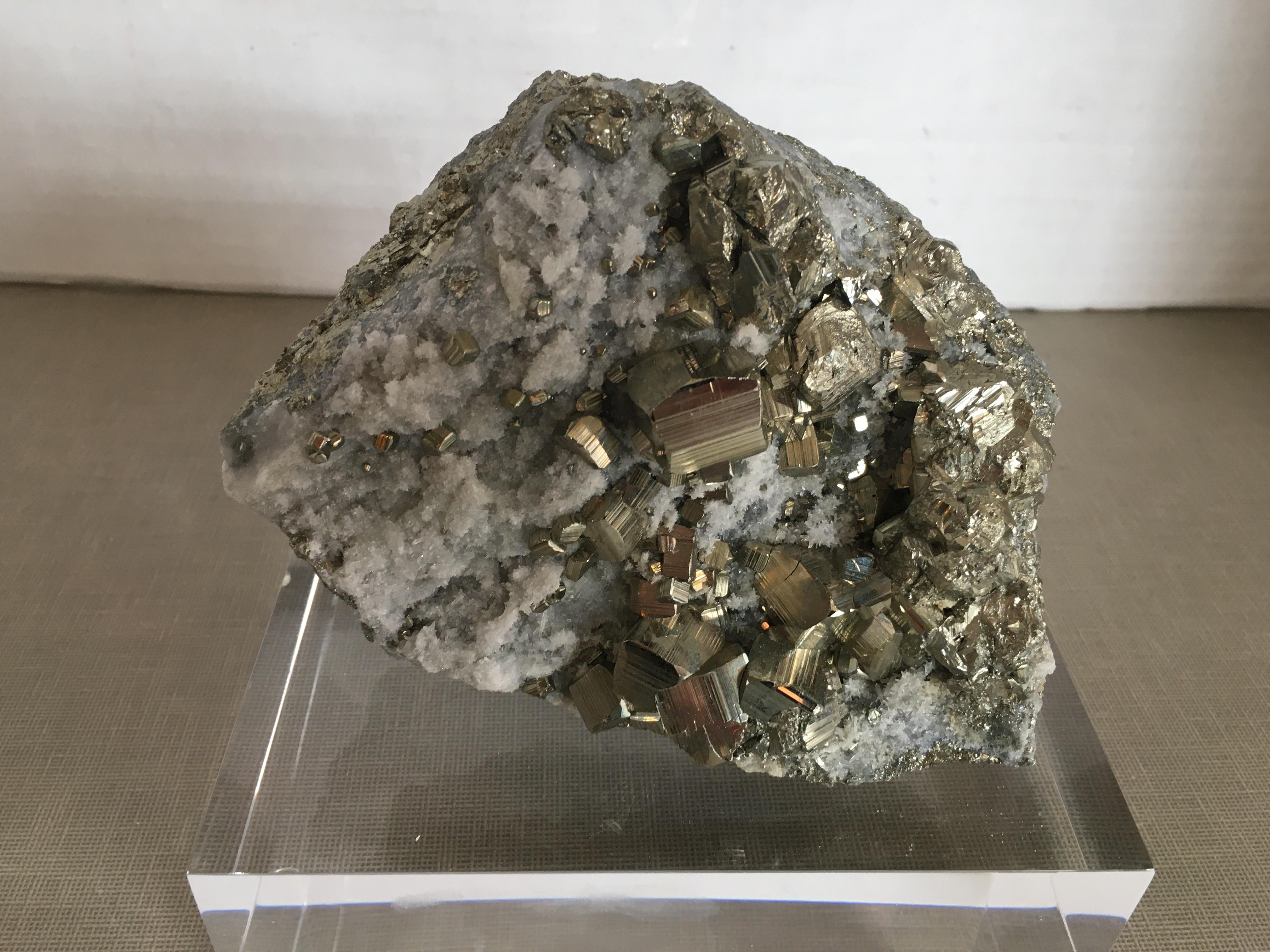 Pyrite with quartz crystals on a Lucite base.