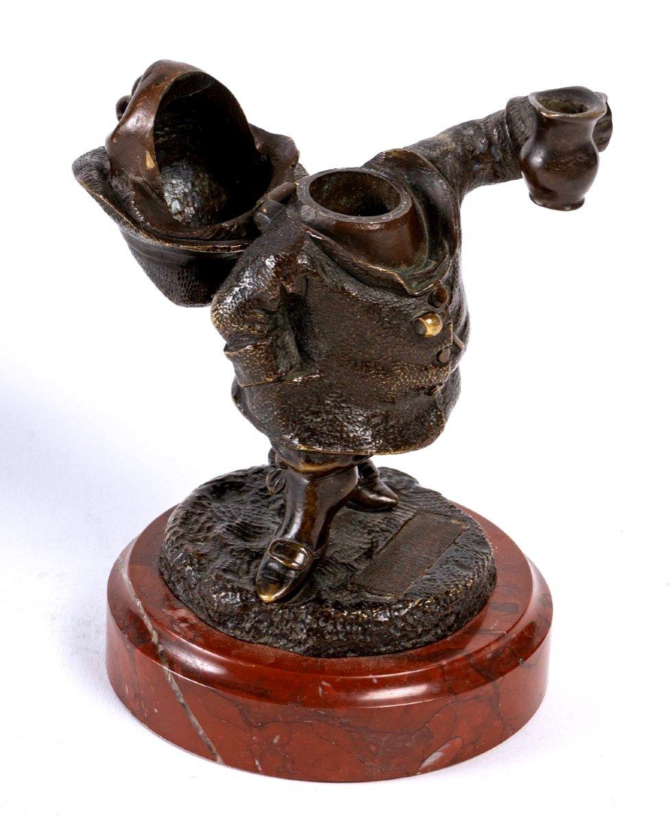 Pyrogen representing a figure in bronze. His face is jovial and he holds a tankard in his left hand. He is screwed on a griotte marble base.
The scraper is between the shoes.

Period: 19th century 
Dimensions : Height : 12cm - Diameter of the