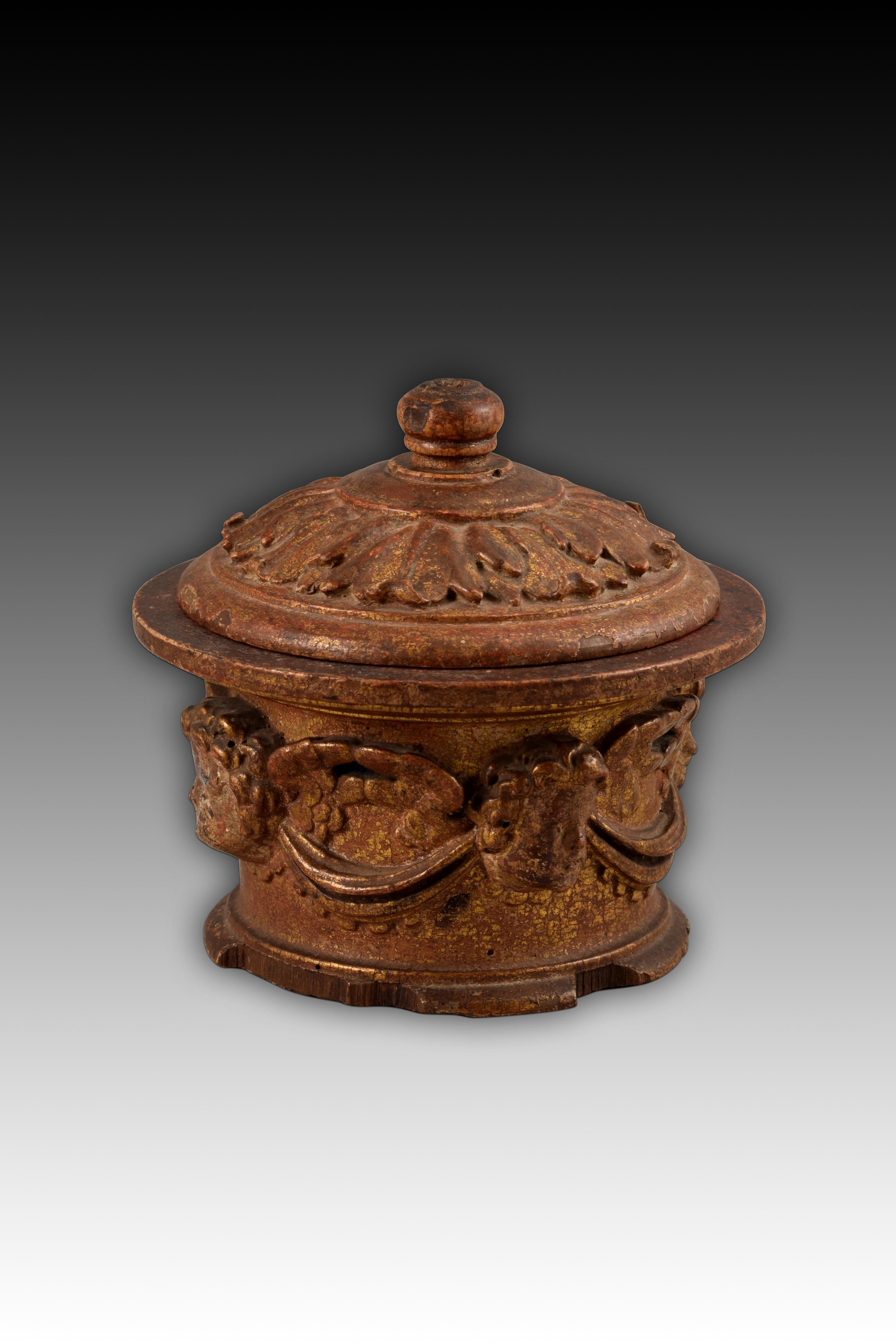 Pyx. Carved and polychrome wood. Spanish school, 16th century. 
Box with a circular base and a frustoconical body that has a vaulted lid topped with a knob with a molding, it is made of carved wood and preserves traces of gilding on its outer