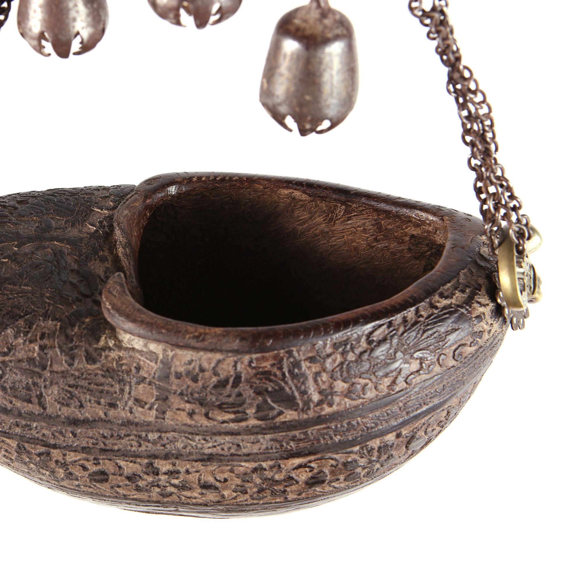 A fine 19th century Persian Kashkul or 'begging bowl' fashioned from half a coco de mer nut and suspended with chains. The sides with flowing foliate borders and sacred figurative scenes also incorporate anamorphic animal details, snakes, tigers,
