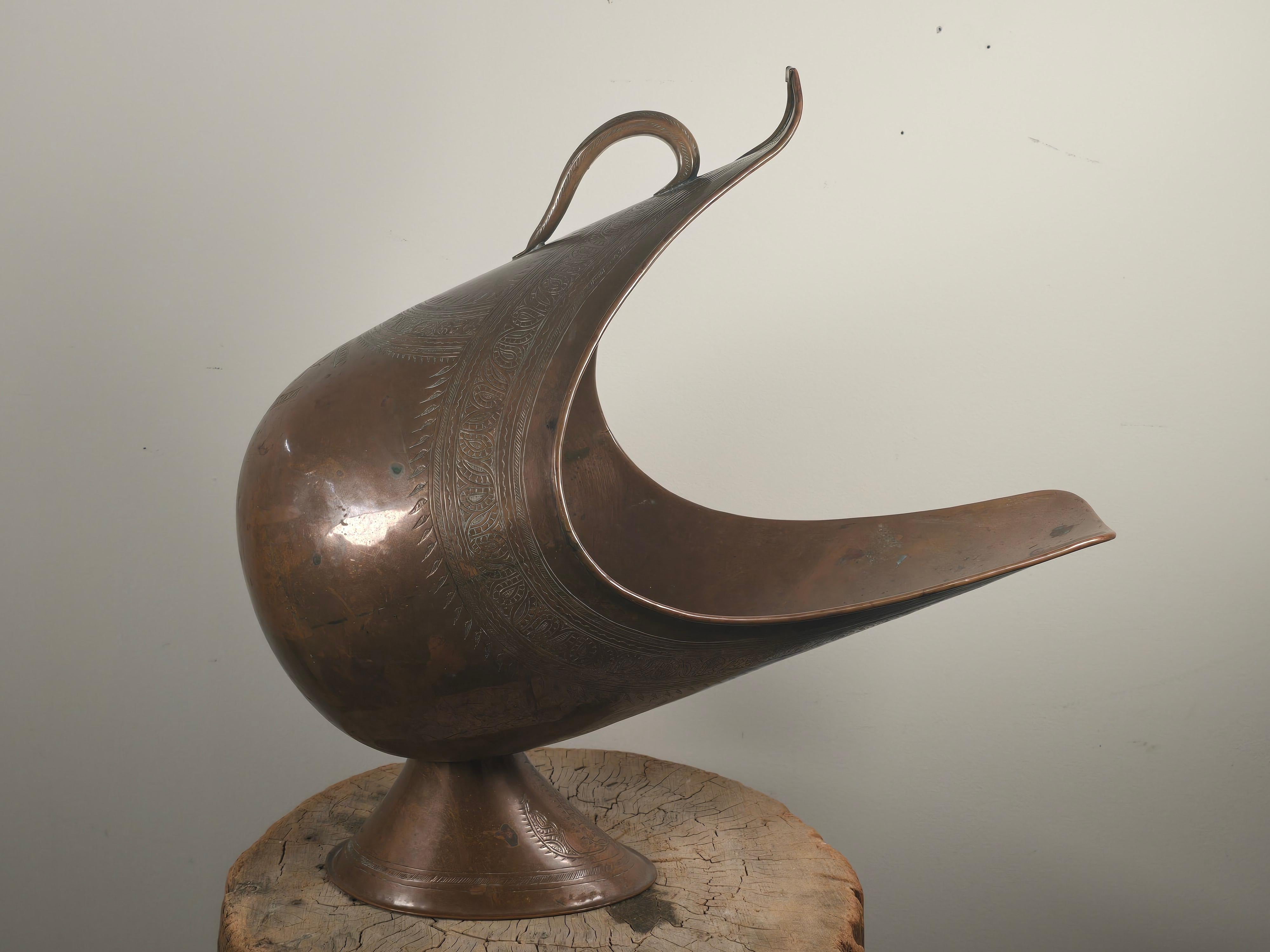This 19th-century Qajar Persian coal scuttle pairs traditional metalwork with an unexpectedly modern silhouette. Its hand-hammered, exaggerated crescent form and looping handle evoke a sense of movement and whimsy-bordering on the surreal. Though