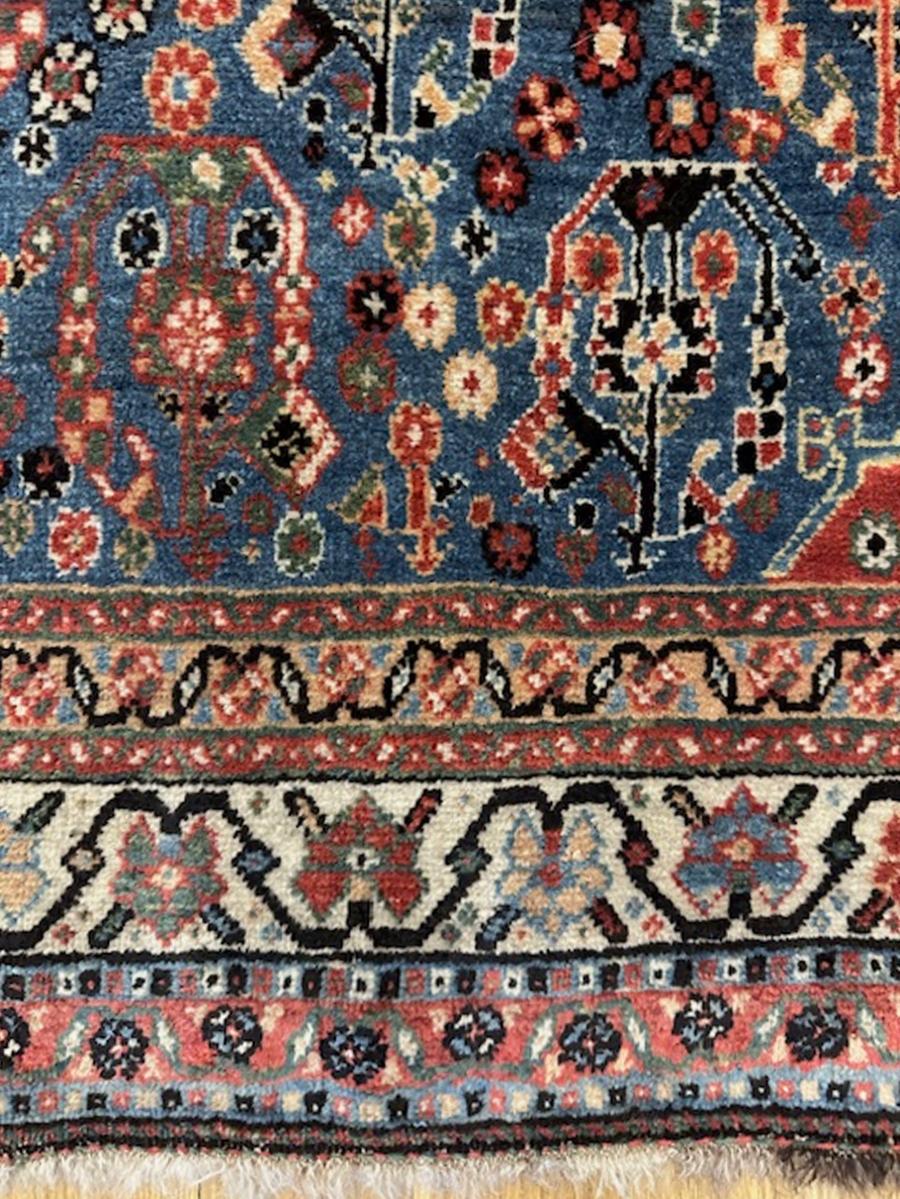 Qashqai rug  from Fars Province,south west Persia (Iran)

Age: circa 1890

Size: 6′.4″x3′.10″ (193×117 cm)

The blue field hosts a diagonal pattern of open floriated stylized botehs in red,ivory,blue,black and yellow.The red corners all display
