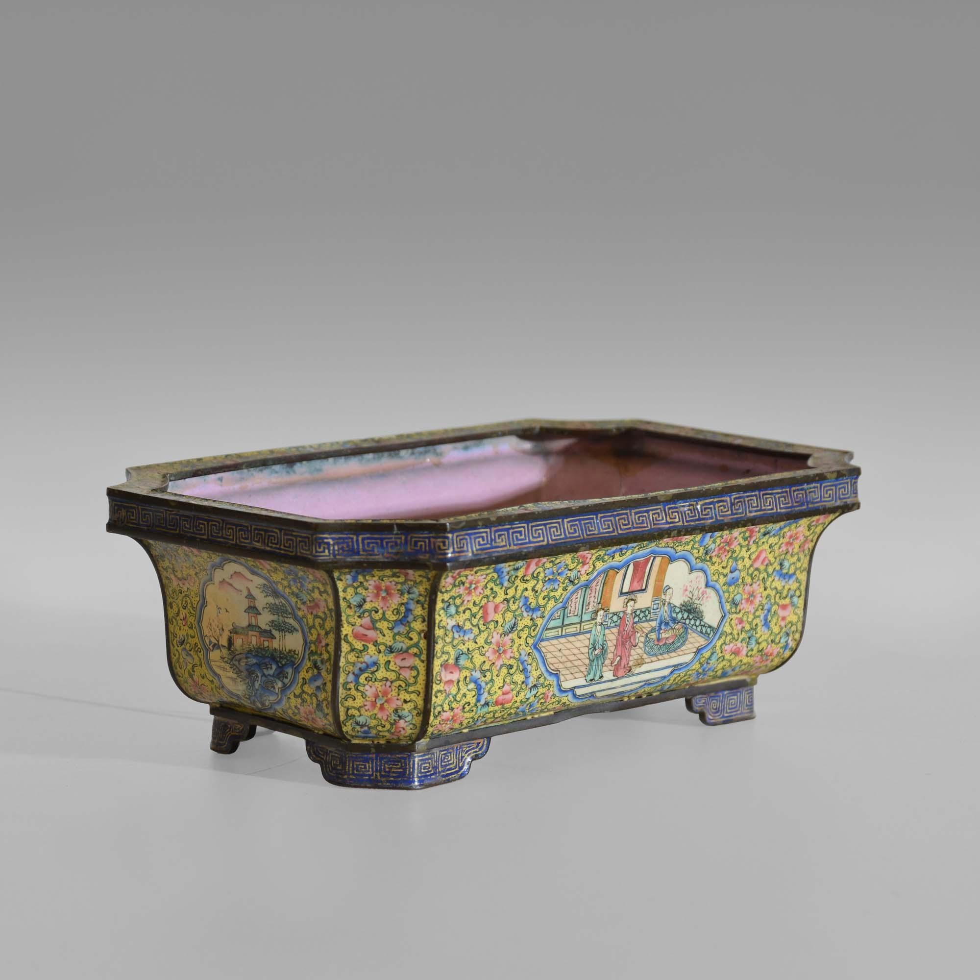 Qianlong Chinese Canton enamel jardinière

18th century Chinese enamel jardinière, bonsai planter.  Rectangular with canted corners of caveto form, the frieze decorated with Greek key decoration as are the bracket feet. The body profusely decorated