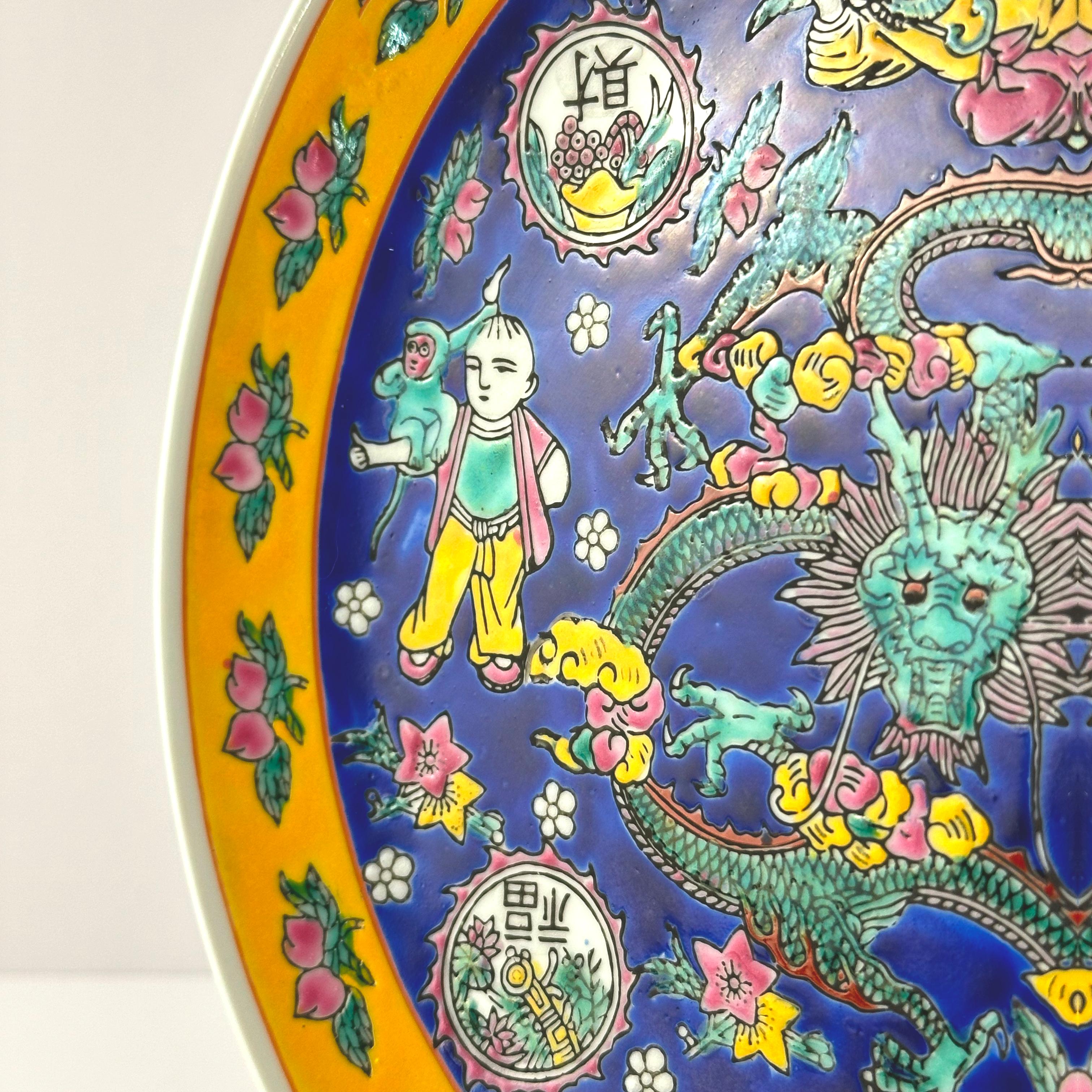 Piatto da portata d'epoca in porcellana smaltata blu e gialla in stile Qianlong, realizzato a mano negli anni '80.

Il caricatore decorativo presenta un'audace composizione policroma con smalti blu cobalto e gialli.  Al centro, un drago verde