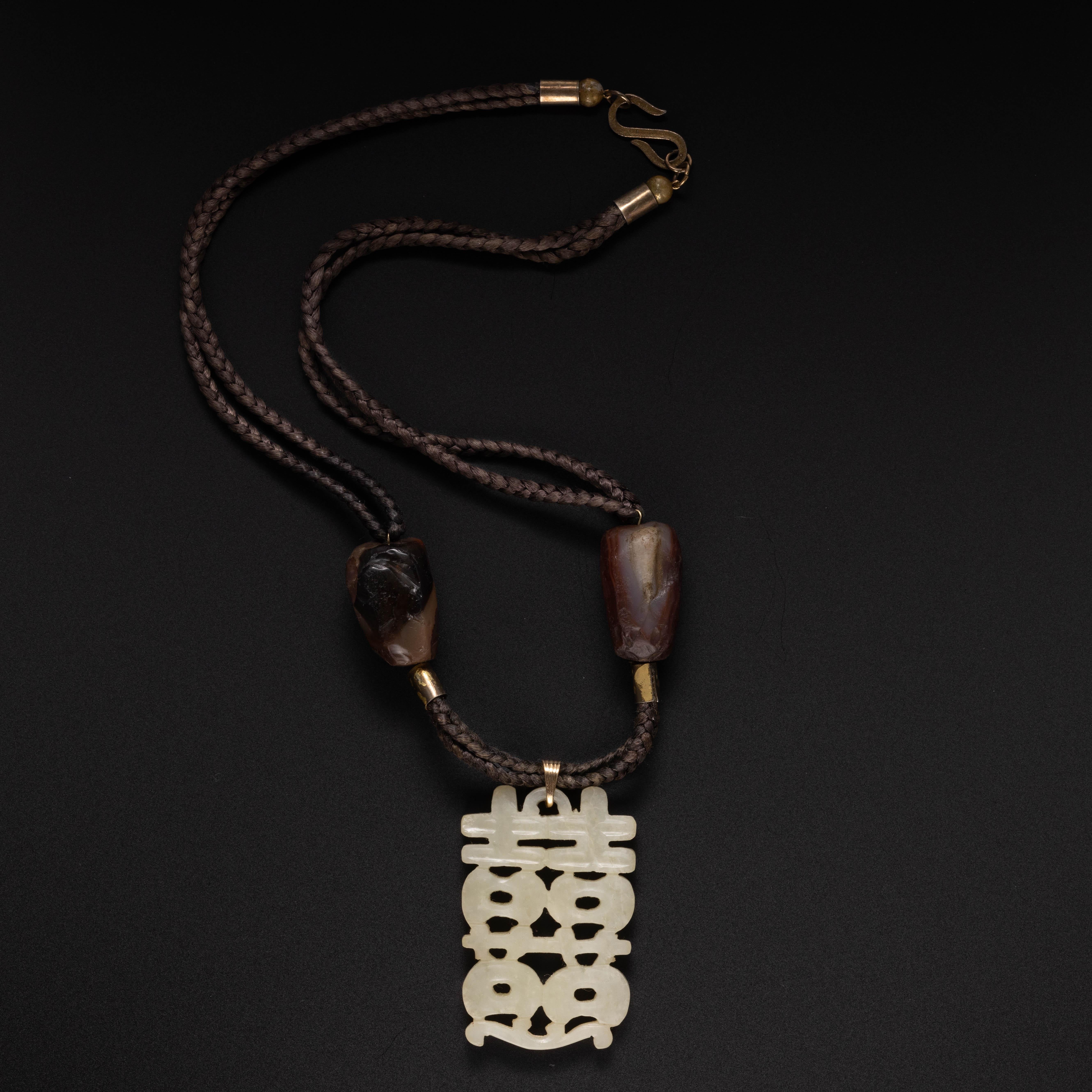 This is a fascinating and beautiful late Qing period Chinese white serpentine and an agate bead pendant. The hardstone is gorgeously carved in a rather unusual fashion, where the stone was 