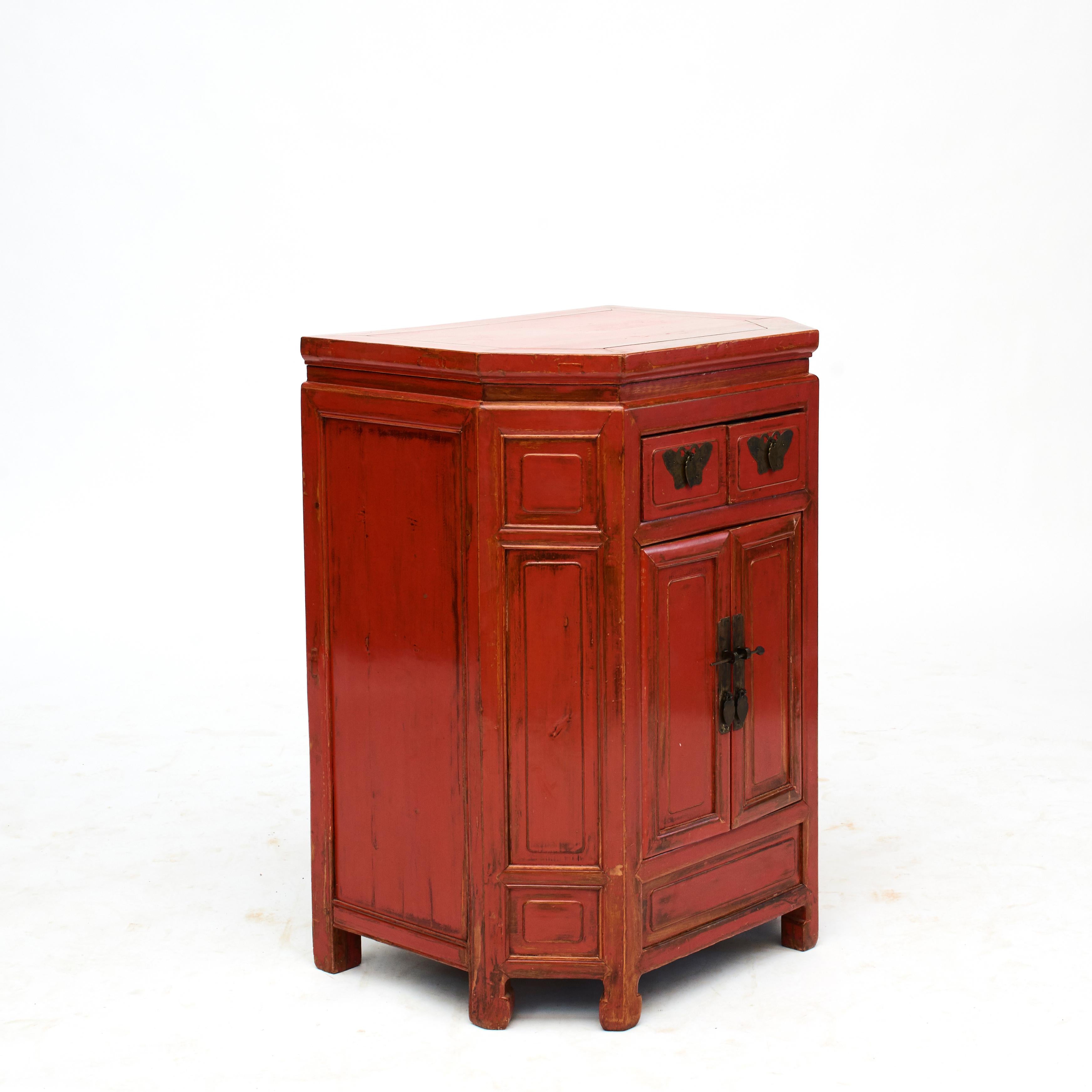 Hexagon shaped console cabinet from Fujian, situated at China's southeast coast.
Elm wood with original red lacquer. Beautiful natural age patina, highlighted by clear lacquer finish.
Original brass mounts, on drawers in shape of butterflies which