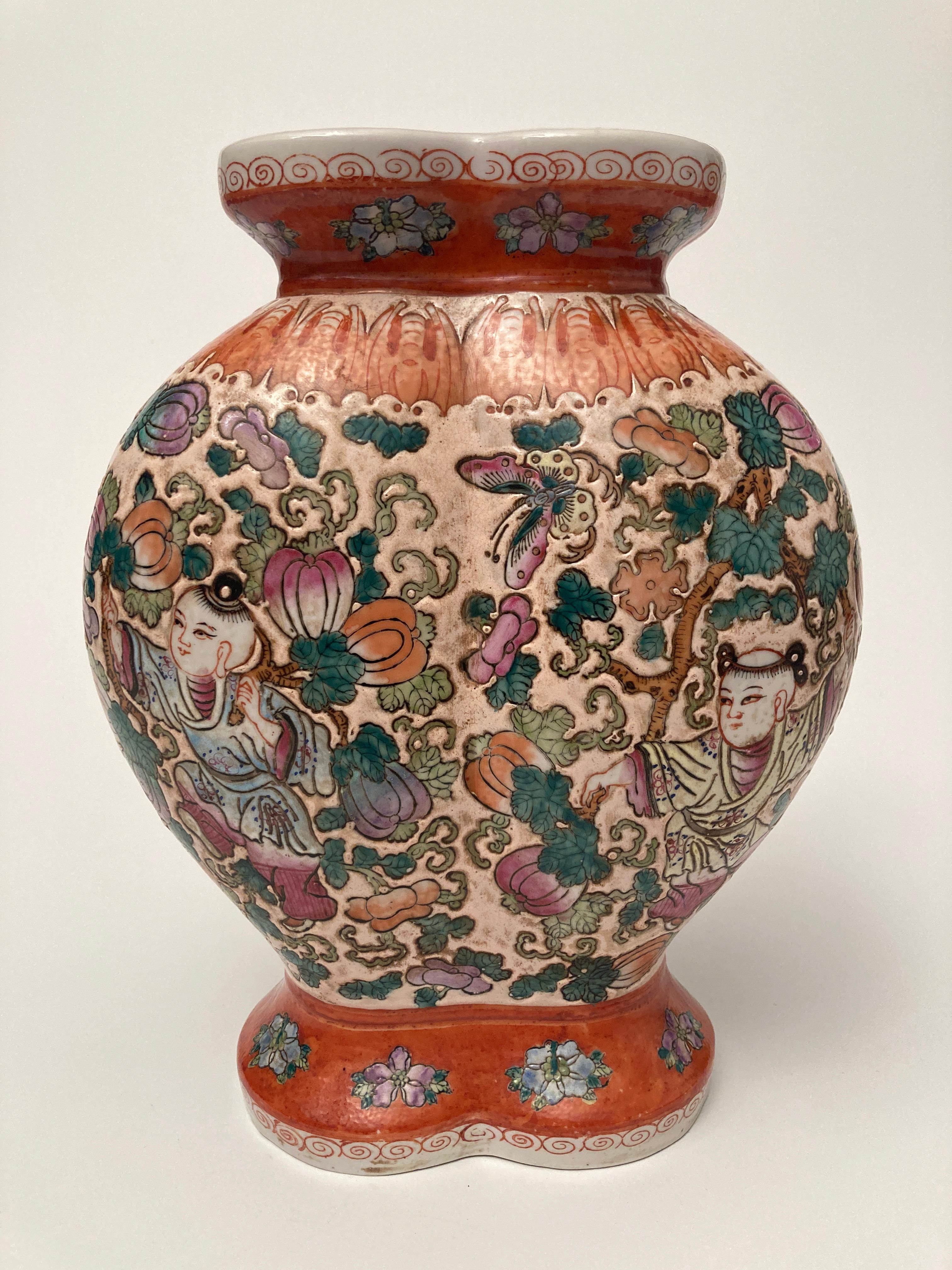 This stunningly enameled porcelain vase has a double mouth opening with hand-painted images of boys playing among the vines, gourds and gourd blossoms. There is a border of bat-like figures above the playful garden images with a finishing trim of