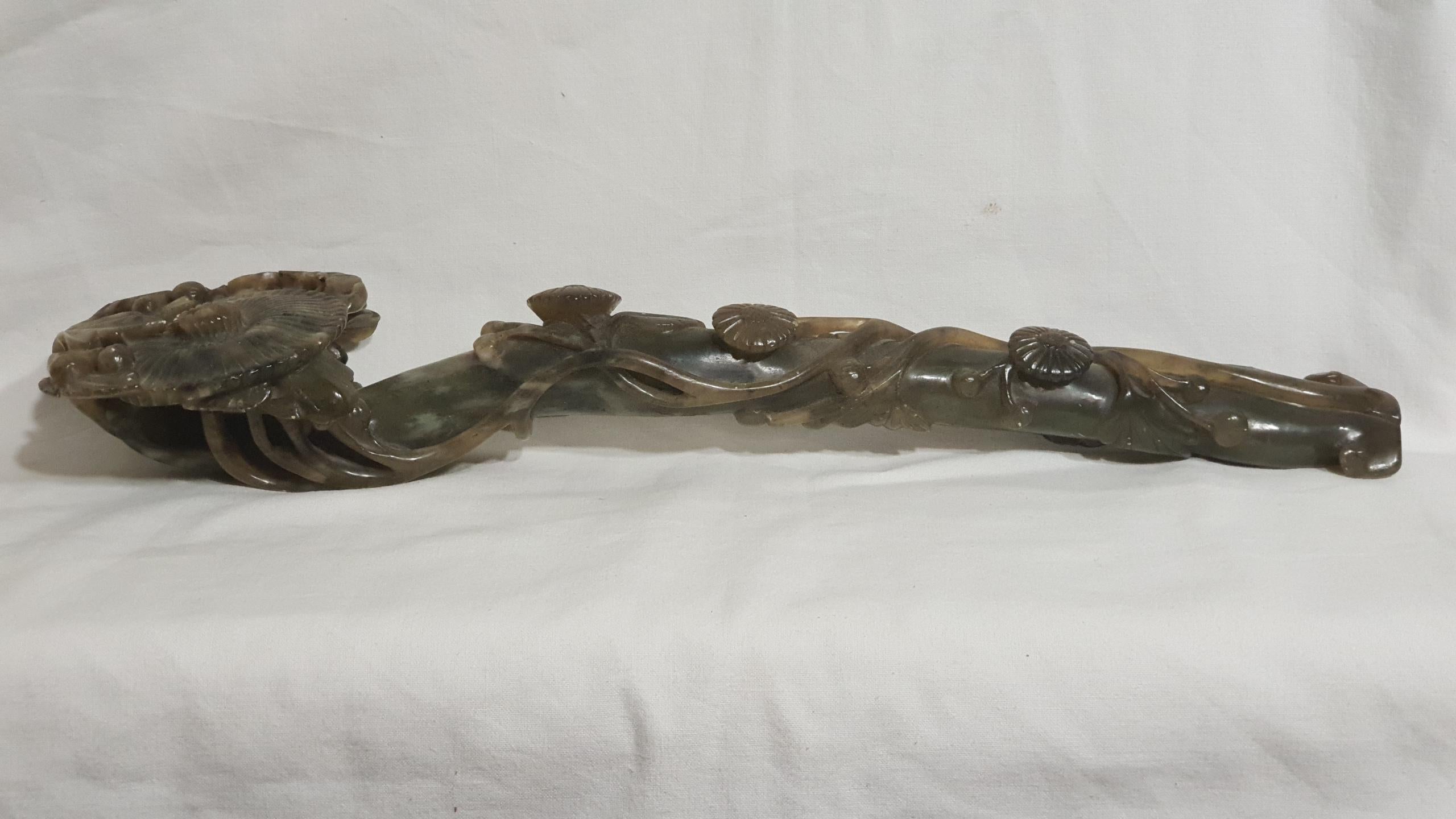 A Chinese green Jade Ruyi Scepter, sculpted with floral motifs
Qing dynasty.