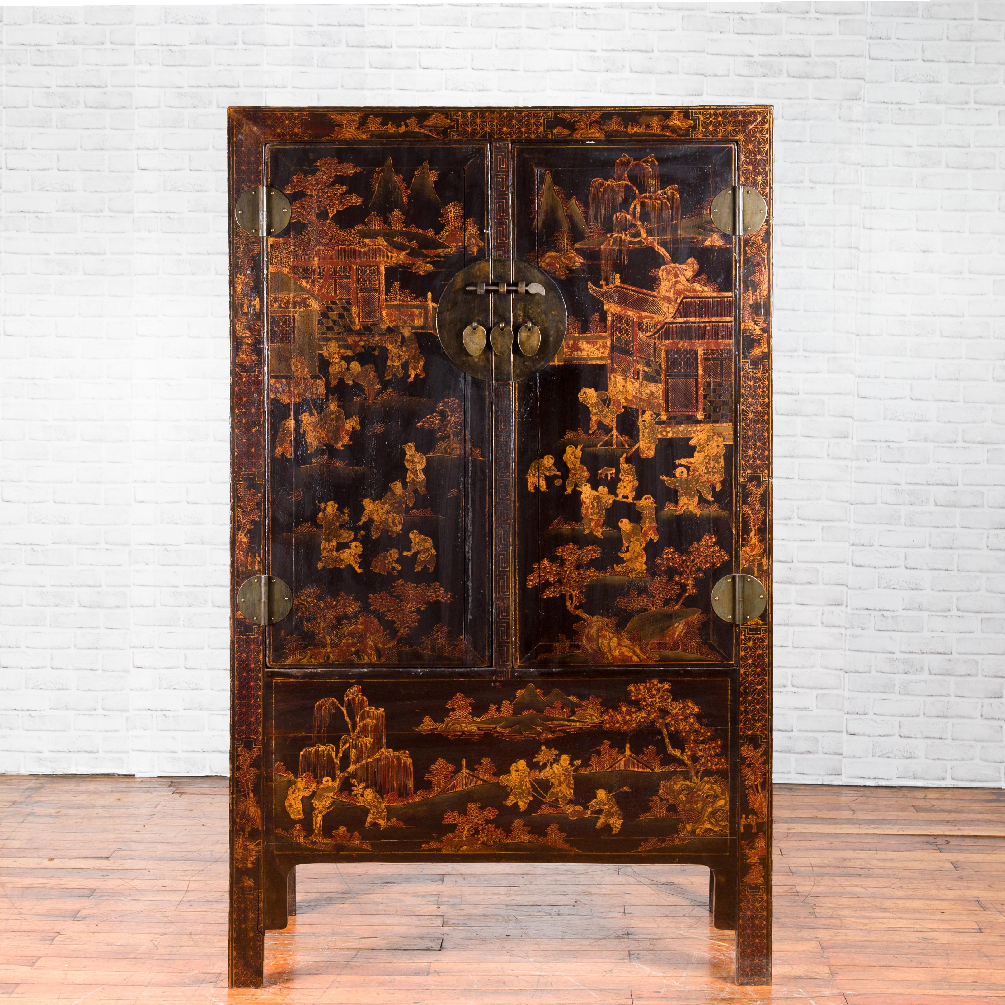A Chinese Qing dynasty period black lacquer cabinet from the 19th century, with gilded chinoiserie decor, doors and hidden drawers. Created in China during the Qing dynasty, this black lacquered cabinet features a delicate golden chinoiserie decor