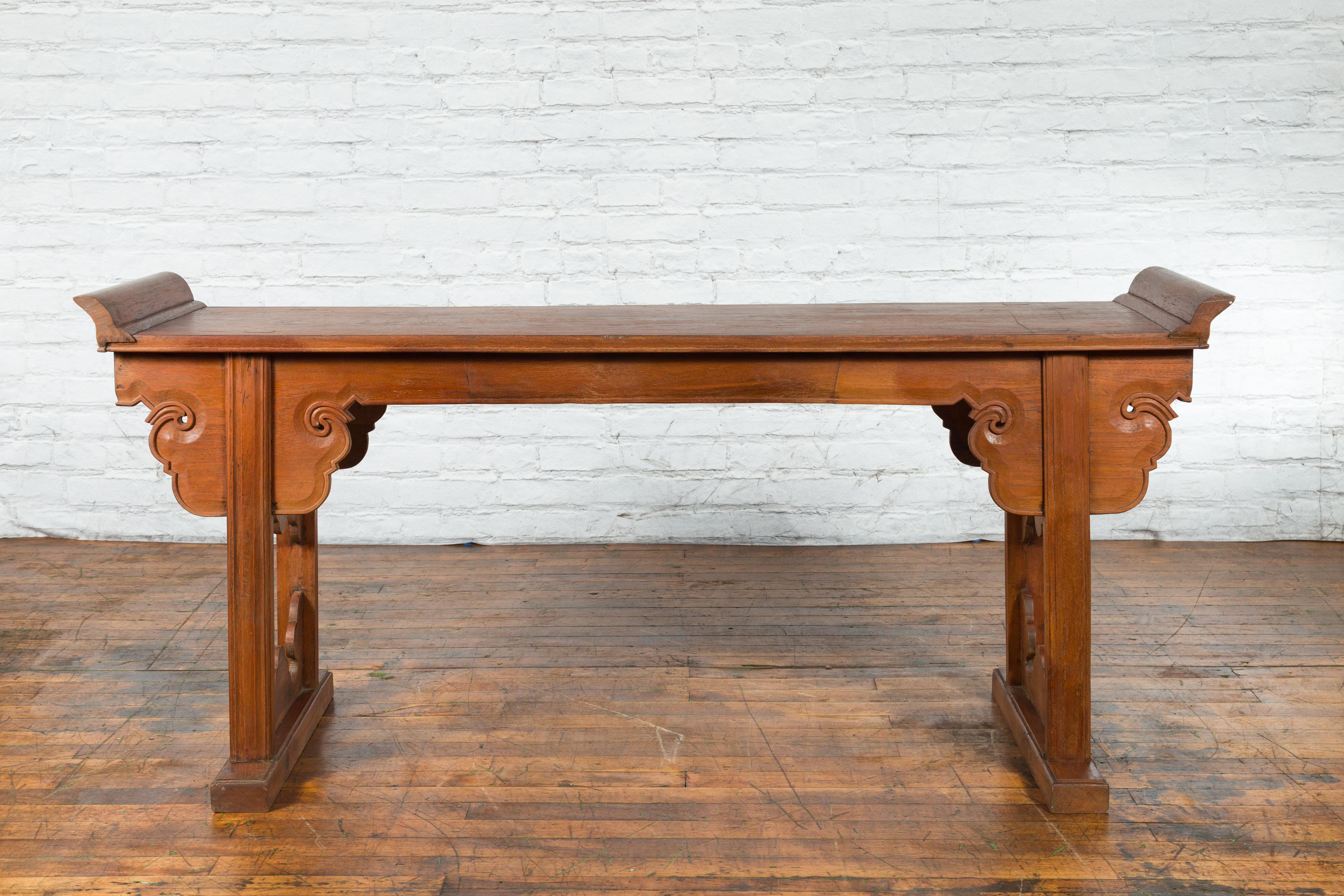 A Chinese altar console table from the late 20th, early 21st century, with carved apron and everted flanges. Created in China during the later years of the 20th century, this console table features a rectangular top flanked with everted flanges,