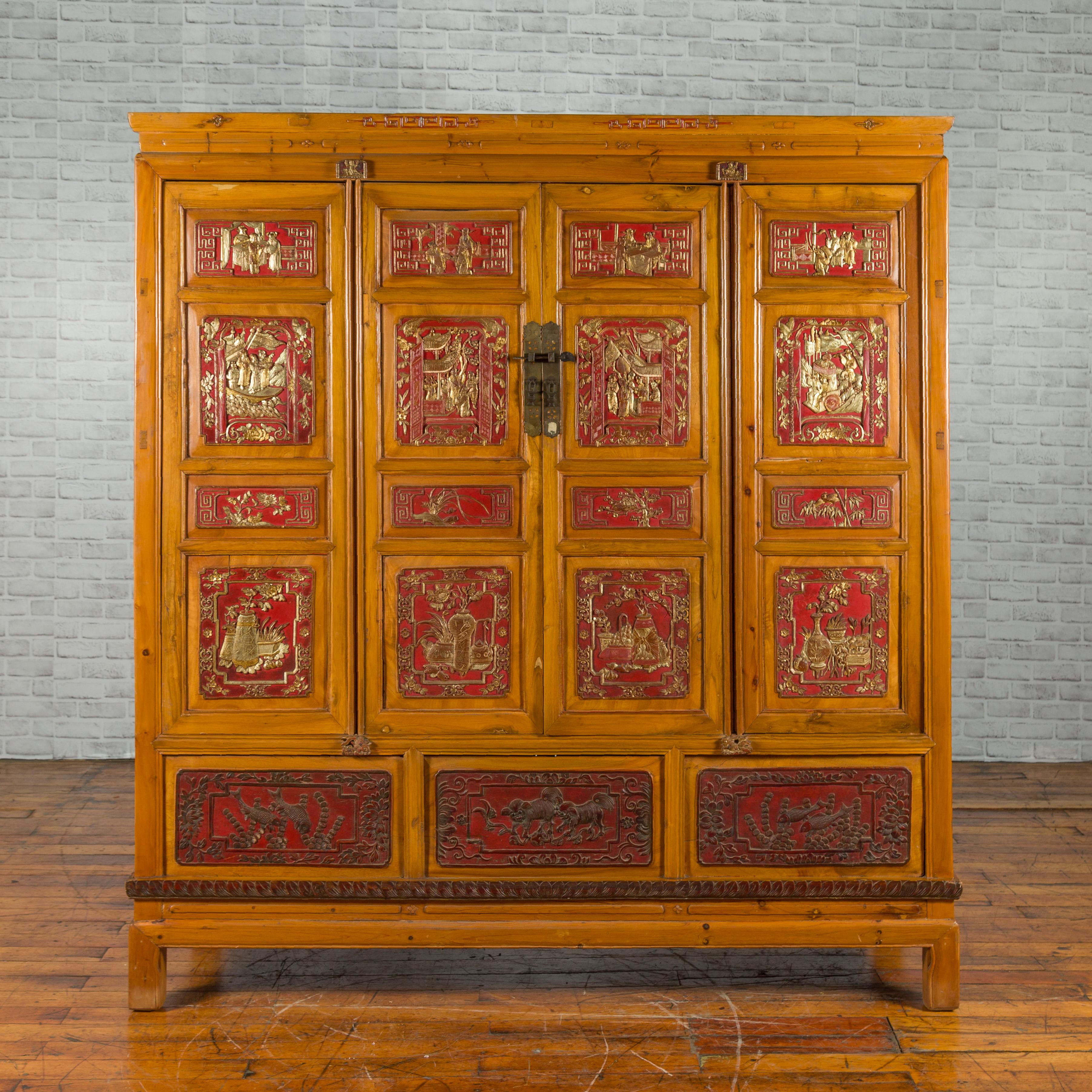 A large Qing dynasty Chinese hand carved, painted and gilded armoire from the 19th century, with 19 panels, four doors and three removable panels revealing a secret compartment. Created in China during the Qing dynasty, this large armoire draws our