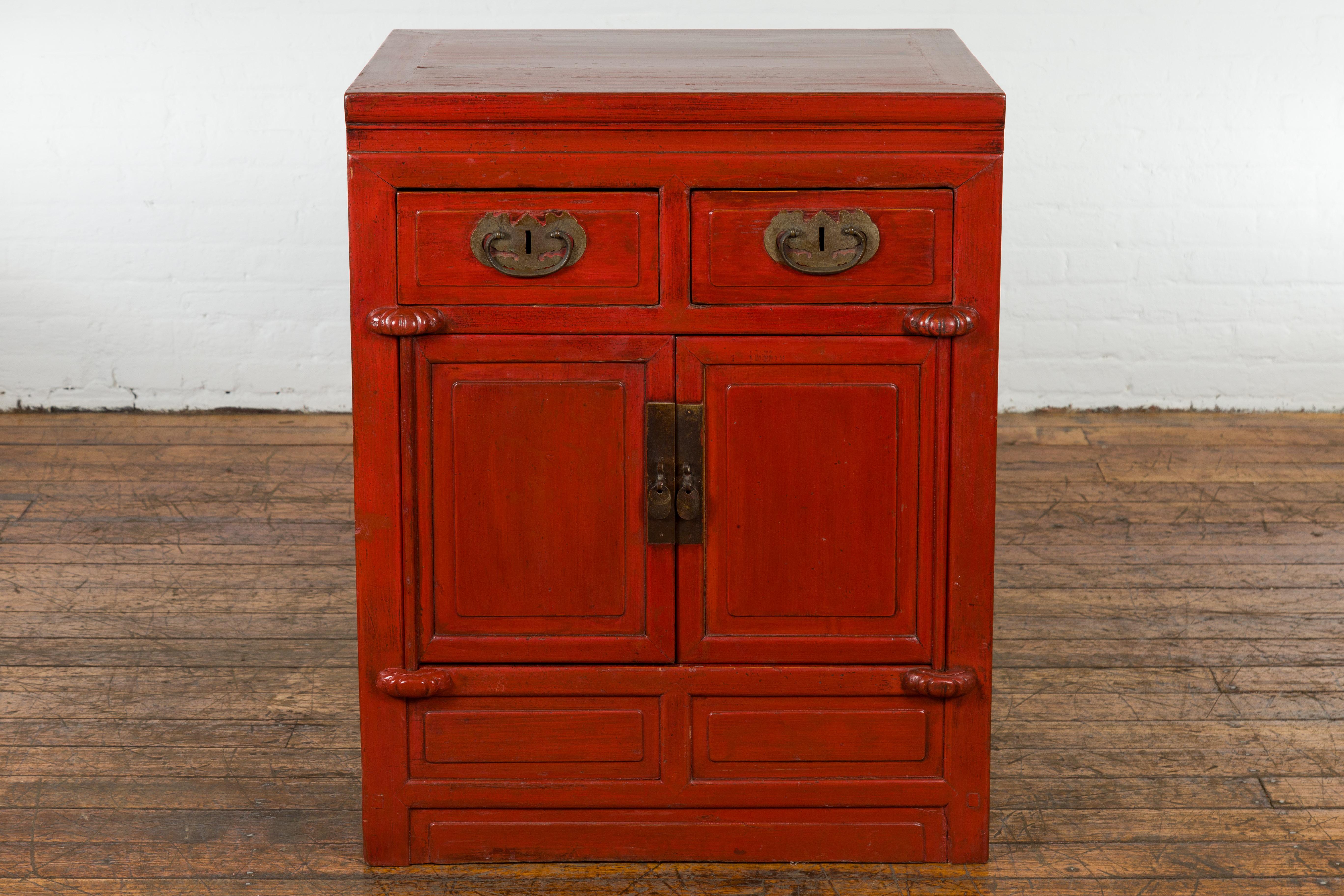 A Chinese Qing Dynasty period red lacquer cabinet from the 19th century. Embrace the allure of antique Chinese craftsmanship with this Qing Dynasty period red lacquer cabinet, a quintessential 19th-century artifact. This antique storage unit