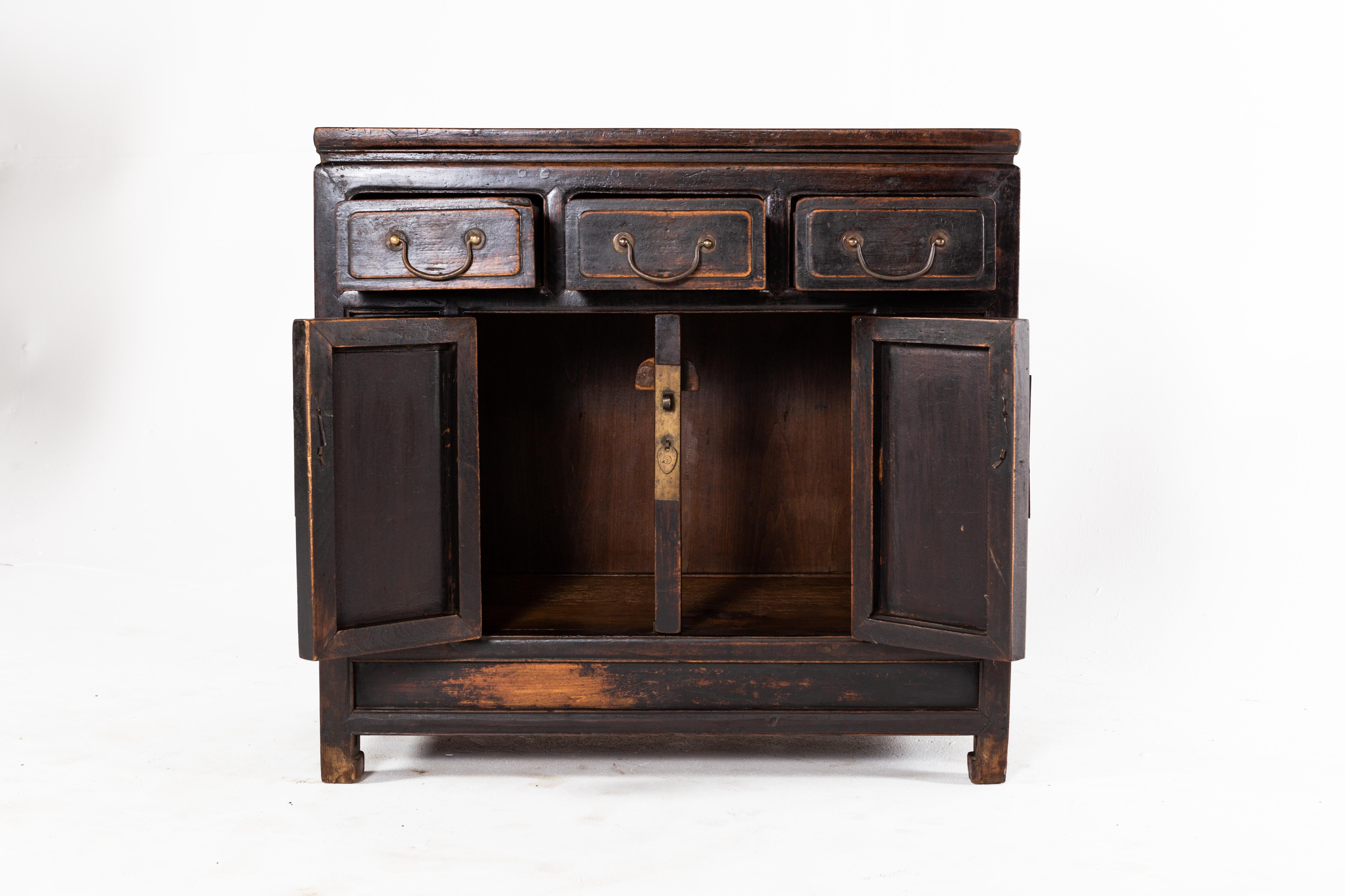 This cabinet is from Beijing, China and was made from walnut, circa 19th Century. The piece features 3 drawers, a pair of doors, its original lacquer, and a shelf for storage. Wear consistent with age and use.