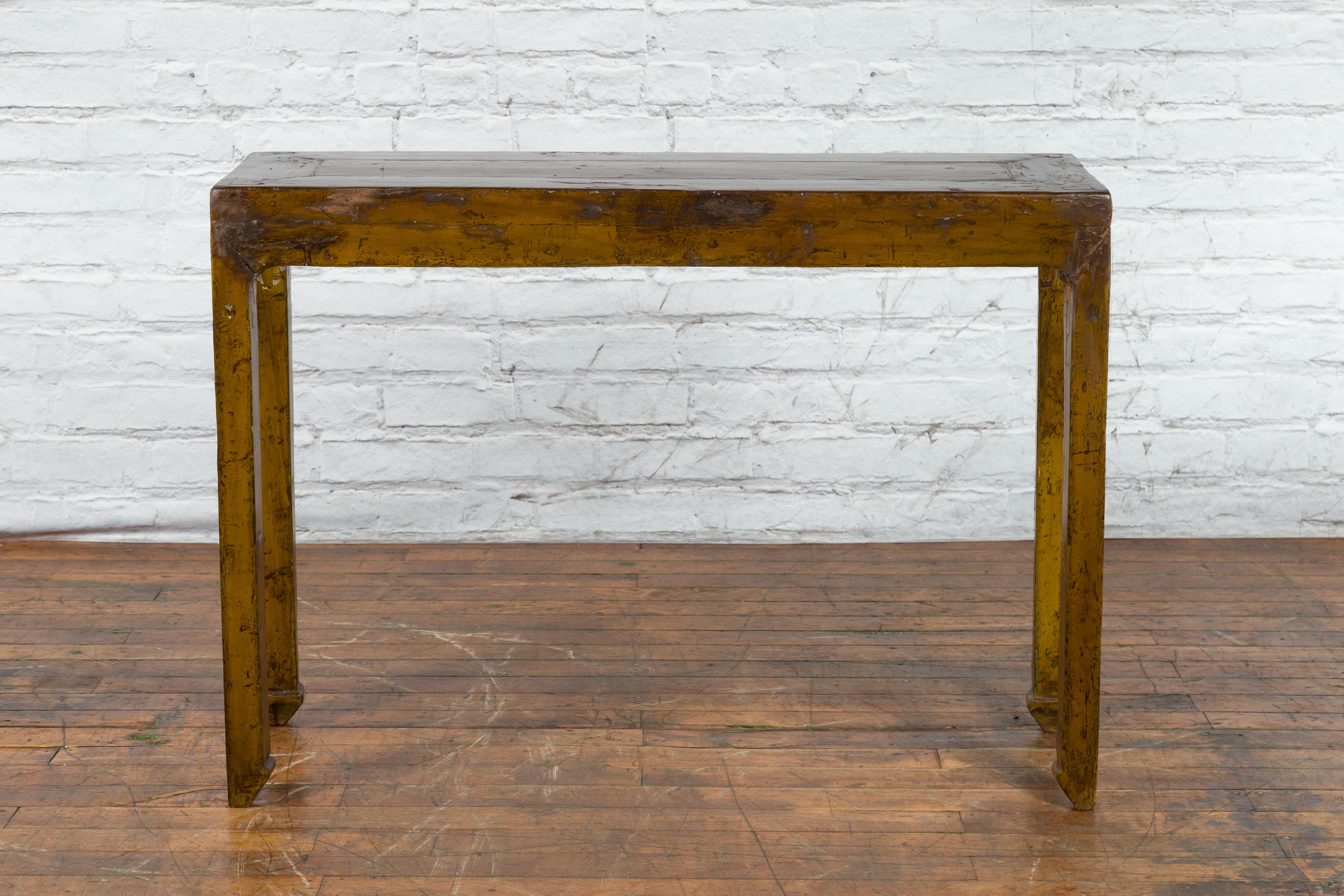 A Chinese Qing Dynasty period brown lacquer altar console table from the 19th century with original distressed patina and horse hoof legs. Created in China during the Qing Dynasty period in the 19th century, this altar console table features a