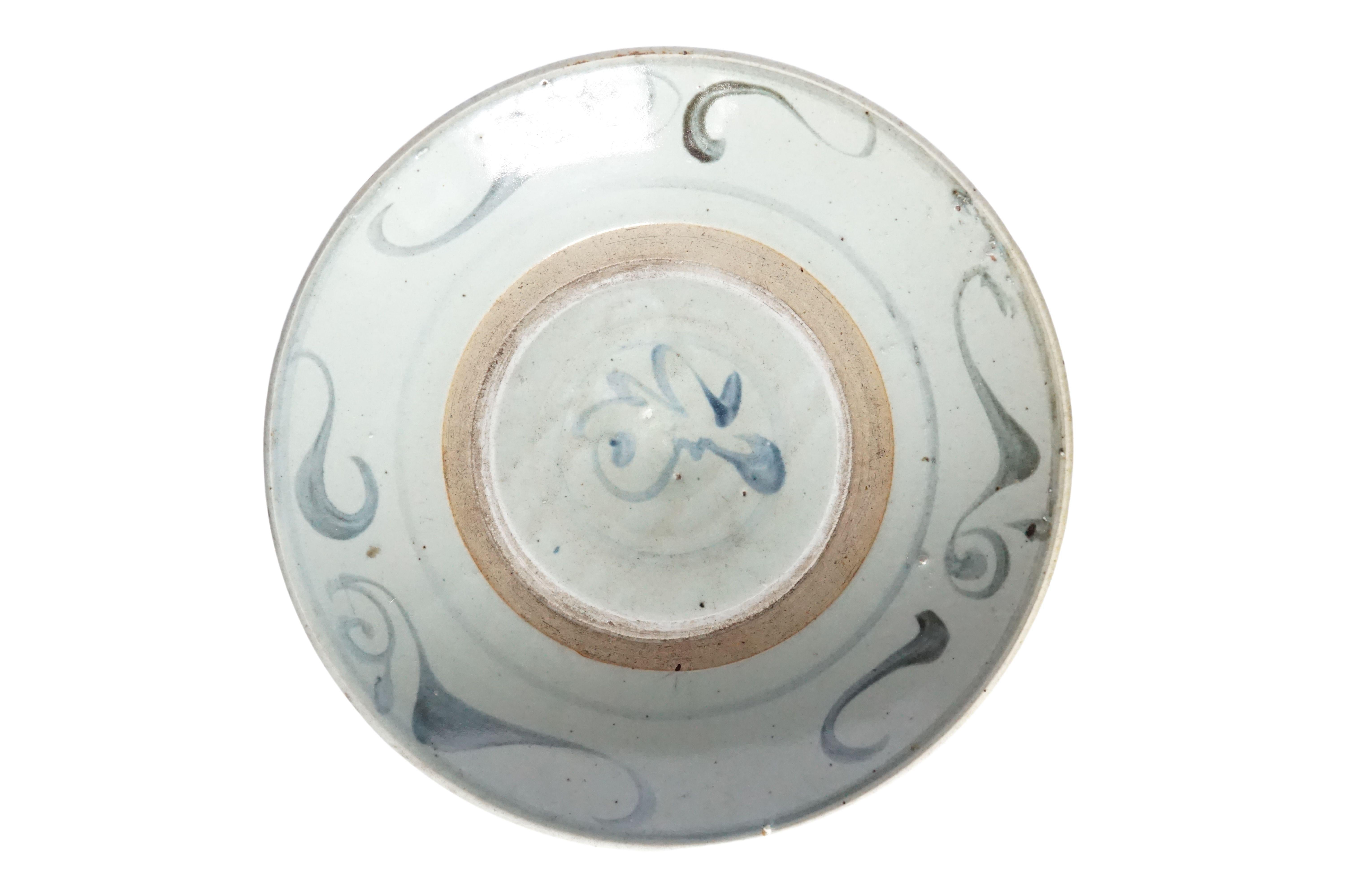 Cette assiette en céramique chinoise est dominée par une glaçure bleu-gris et présente de magnifiques traits de bleu peints à la main. Utilisée autrefois comme assiette de tous les jours, elle est aujourd'hui un bel exemple de céramique chinoise et