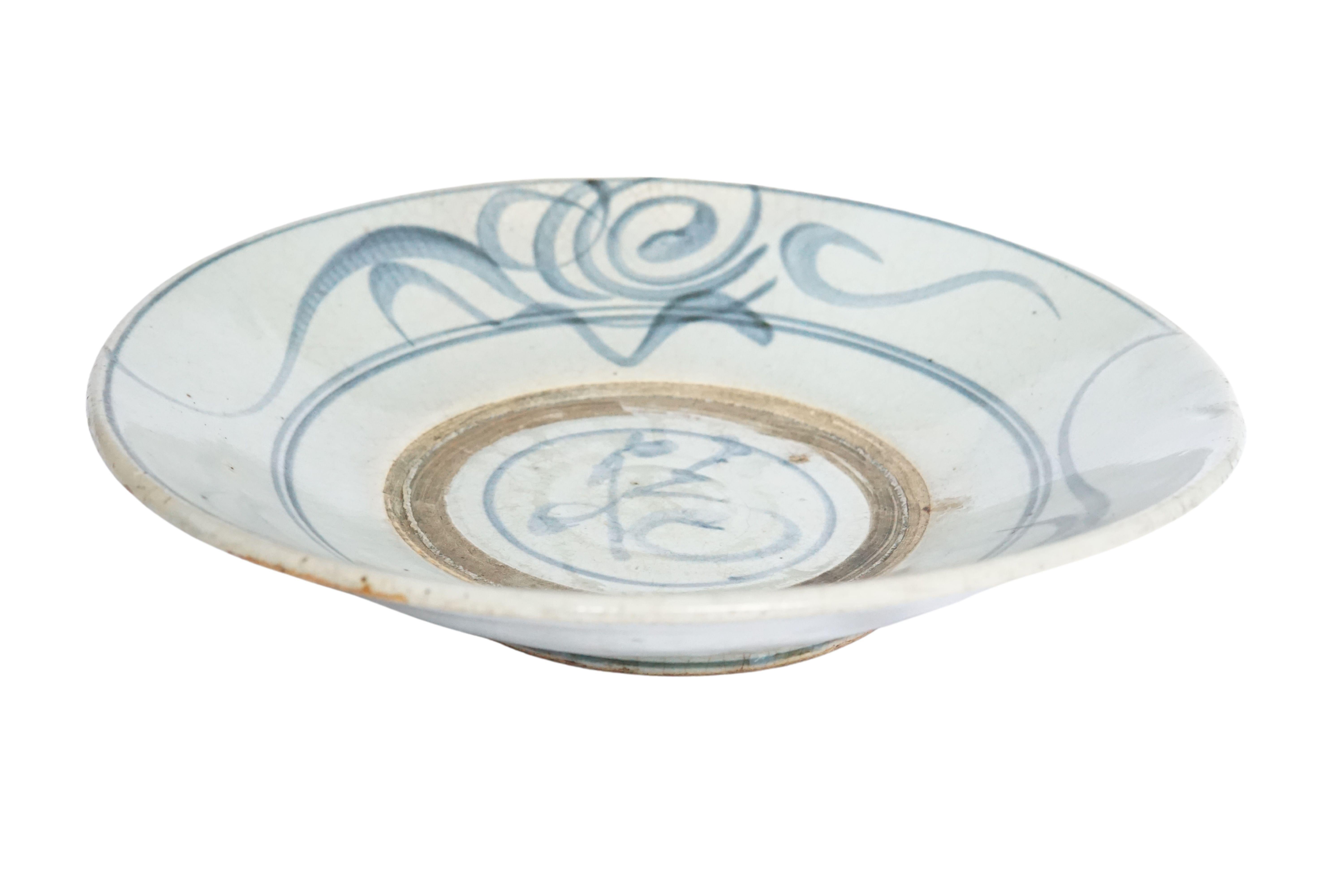 Dieser chinesische Keramikteller aus der Qing-Dynastie wird von einer blau-grauen Glasur dominiert und weist wunderschöne handgemalte blaue Striche auf. Einst als alltäglicher Teller verwendet, ist er heute ein großartiges Beispiel für chinesische