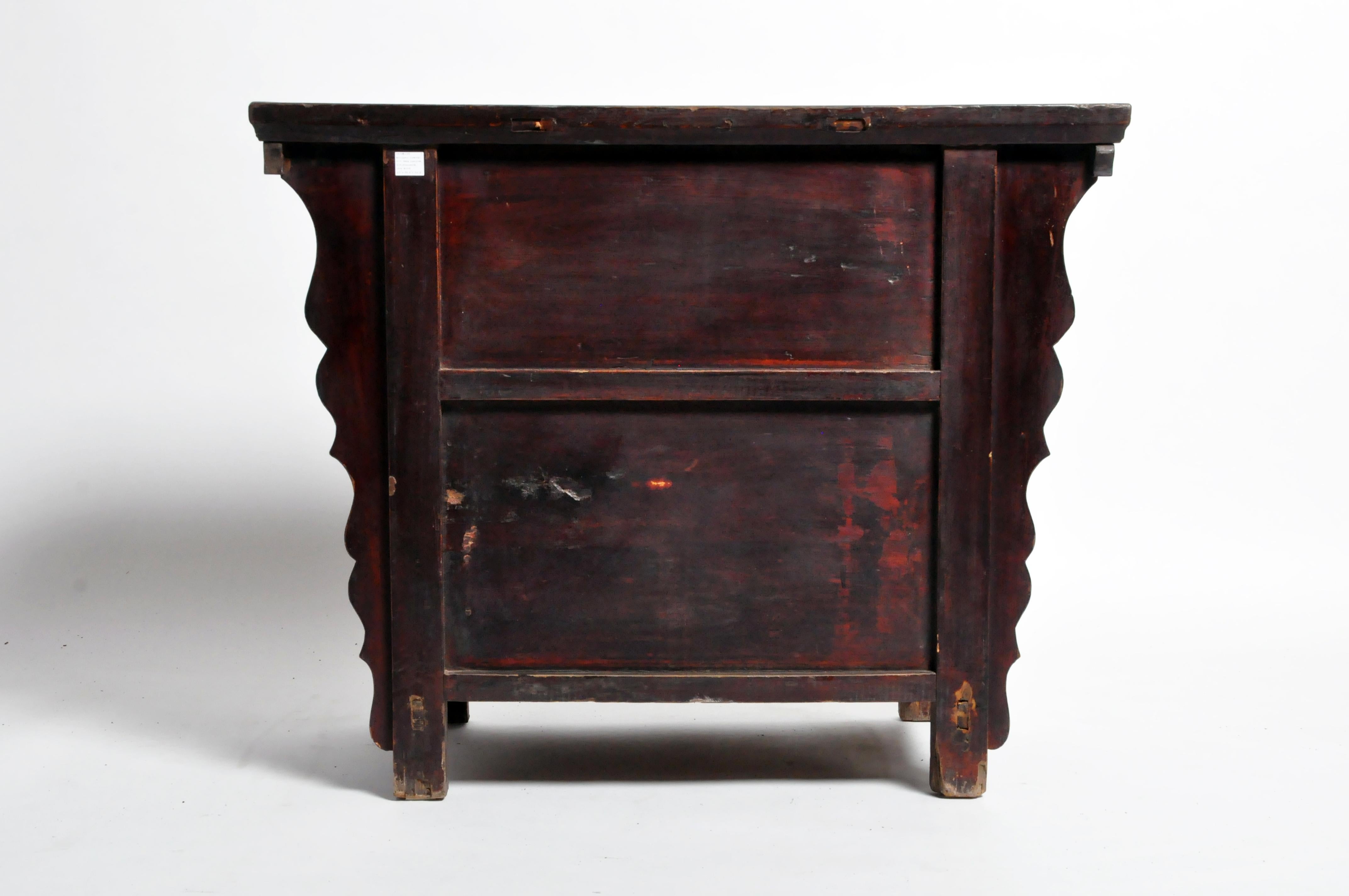 This Qing dynasty butterfly cabinet is from Shandong, China and was made from elmwood and lacquer, circa 19th century. The piece features 2 drawers, a pair of doors, and its original patina. Wear consistent with age and use.