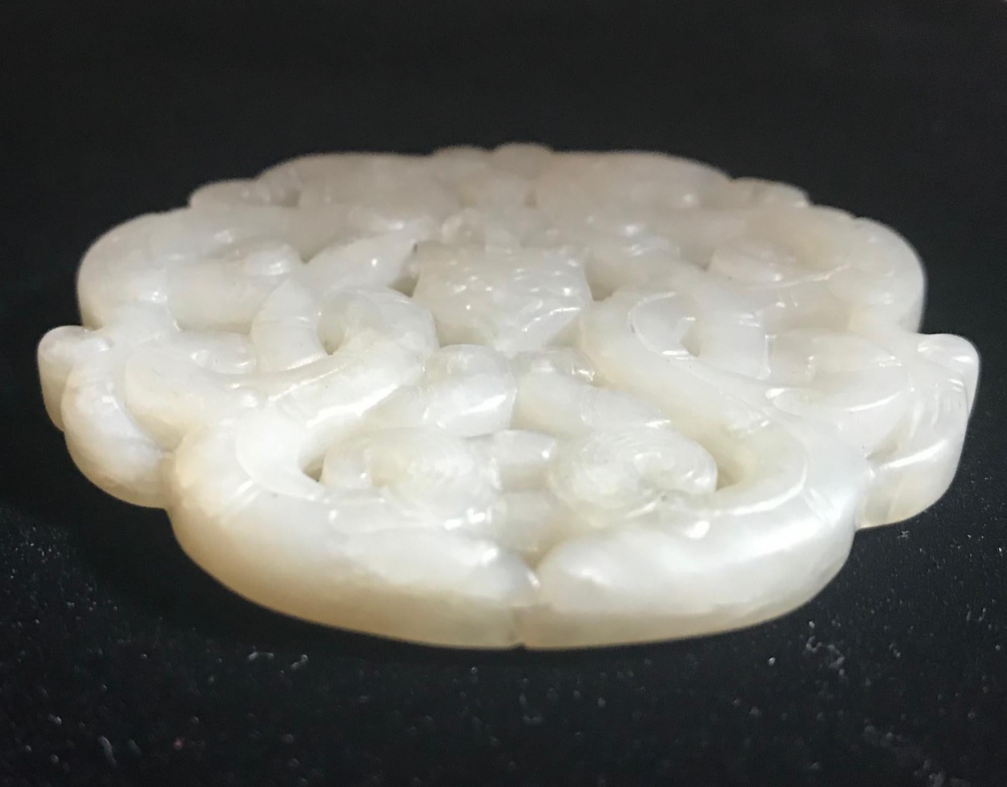 This Qing dynasty detailed carving of glowing jade is pierced and incised throughout with an intricate and balanced design. The medallion features dragons intertwined and centered on a crest. Both sides are beautifully and finely carved.

Condition: