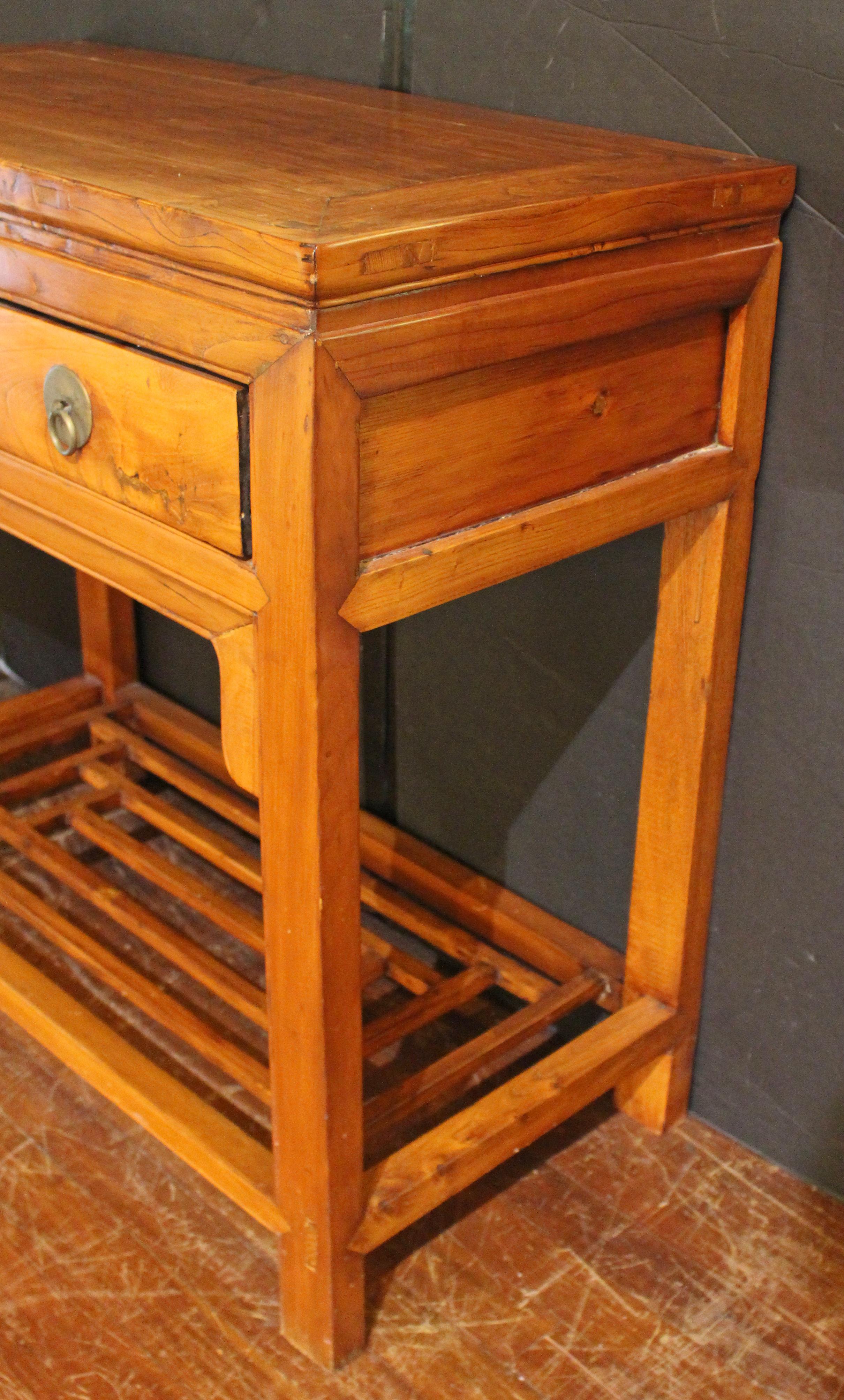 Table console de la dynastie Qing, chinoise. Fabriqué en Ym Mu (orme). Dessus de panneau flottant, surmontant deux tiroirs avec quincaillerie en métal (peut-être en paktong) à disque et anneau tourné, surmontant une ouverture à tablier encadrée avec