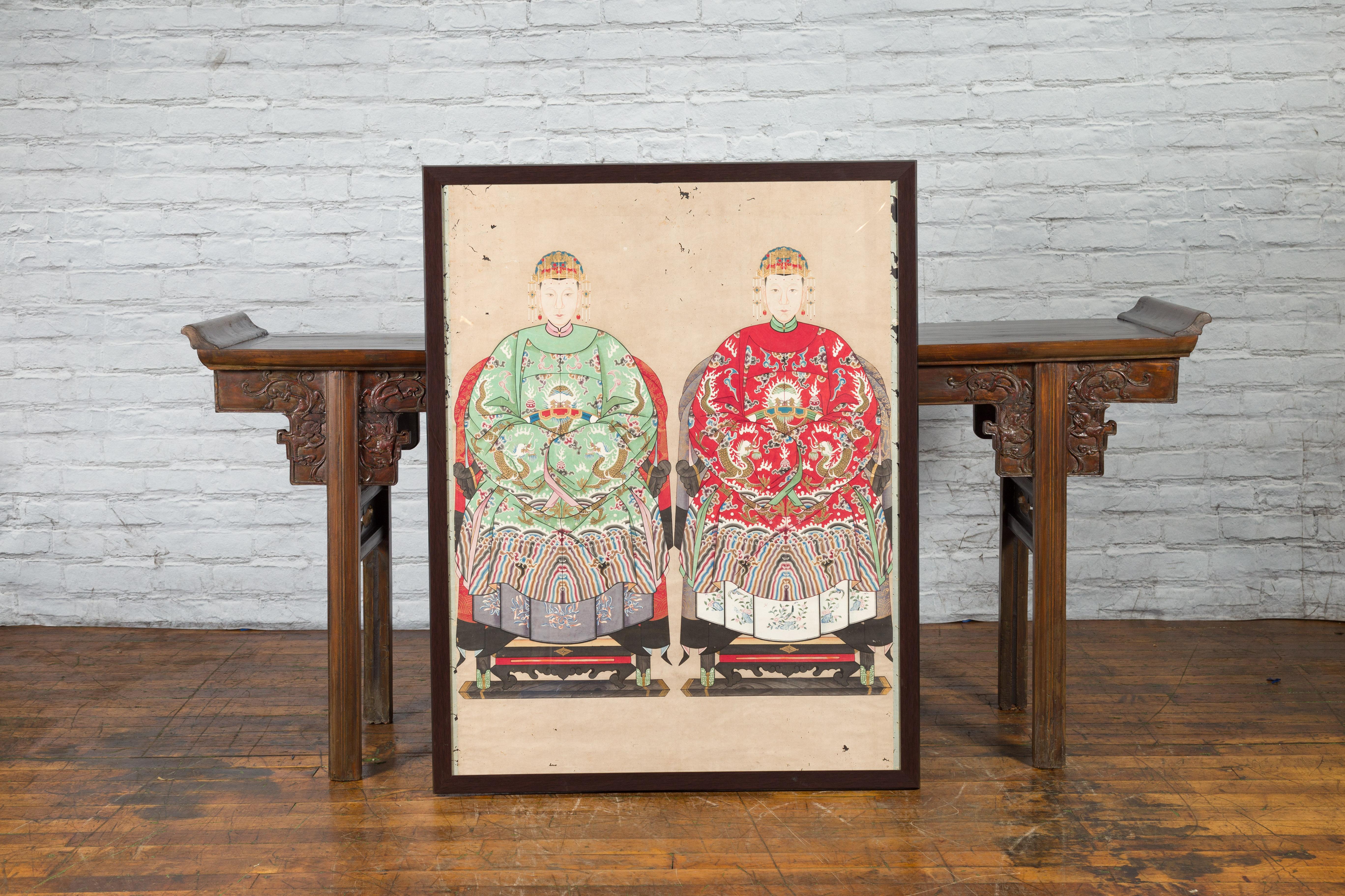 A Chinese late Qing Dynasty period framed painting from the early 20th century of a royalty related couple with dragon motifs painted on a linen canvas. Created in China during the late Qing Dynasty in the early years of the 20th century, this