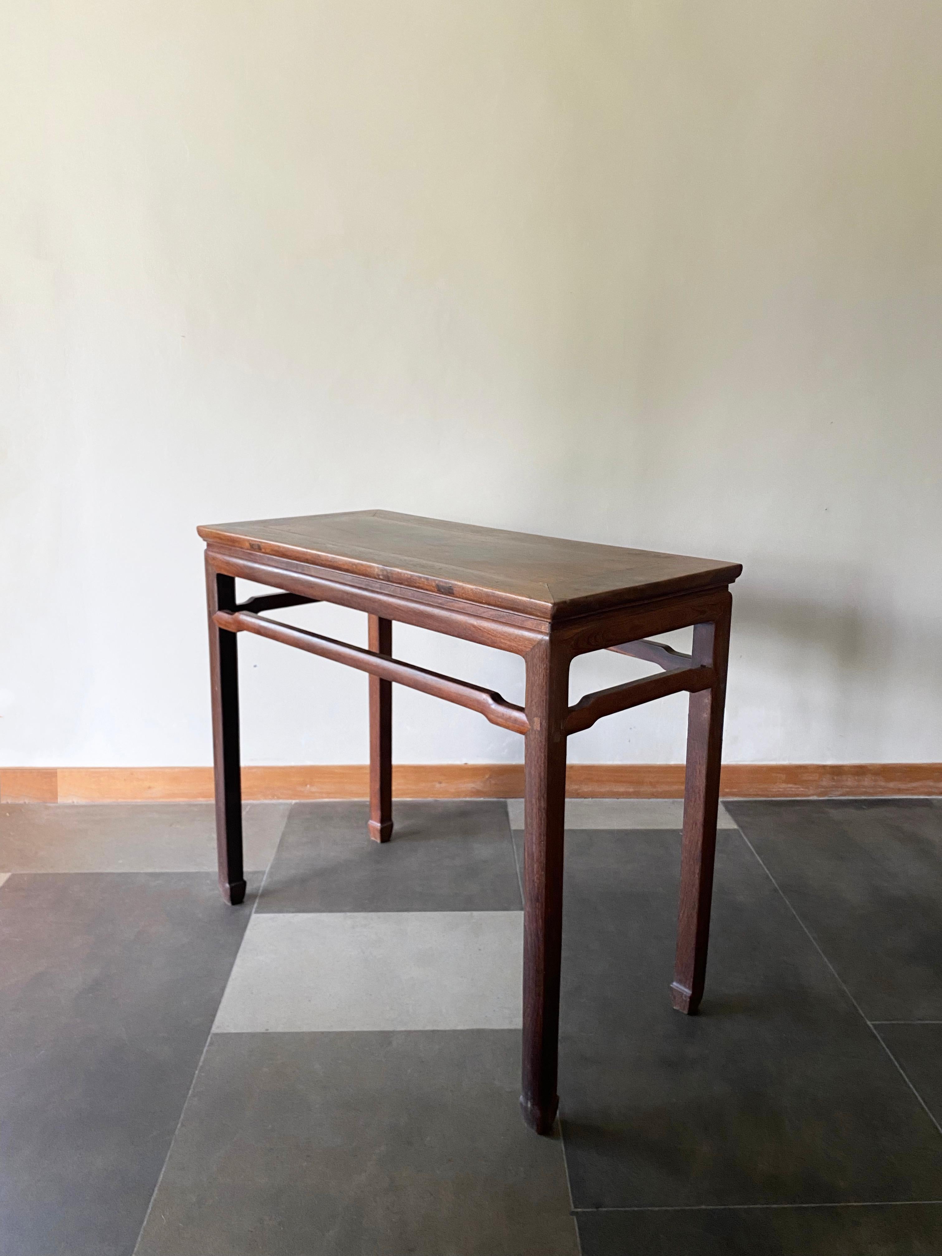 Cette élégante table console a été fabriquée en Chine du Nord au début du XXe siècle. Fabriquée en bois de fer, cette table est unique, car la majorité des tables de ce style étaient fabriquées en bois d'orme. Il présente des pieds élégants, longs