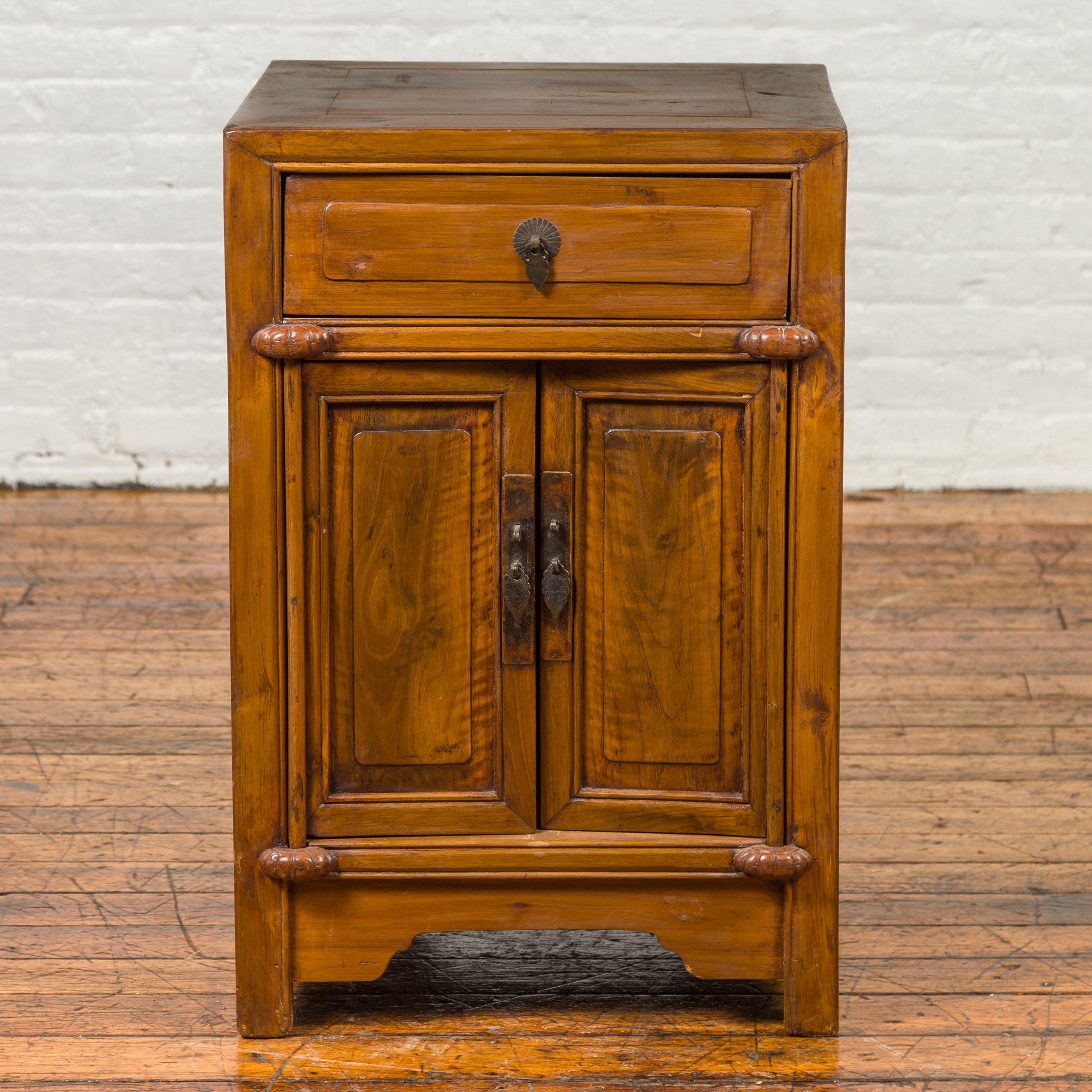 An antique Qing Dynasty period natural elmwood side chest from the 19th century, with single drawers and doors. Crafted in China during the Qing Dynasty, this elm side chest features a square top sitting above a single drawer fitted with teardrop