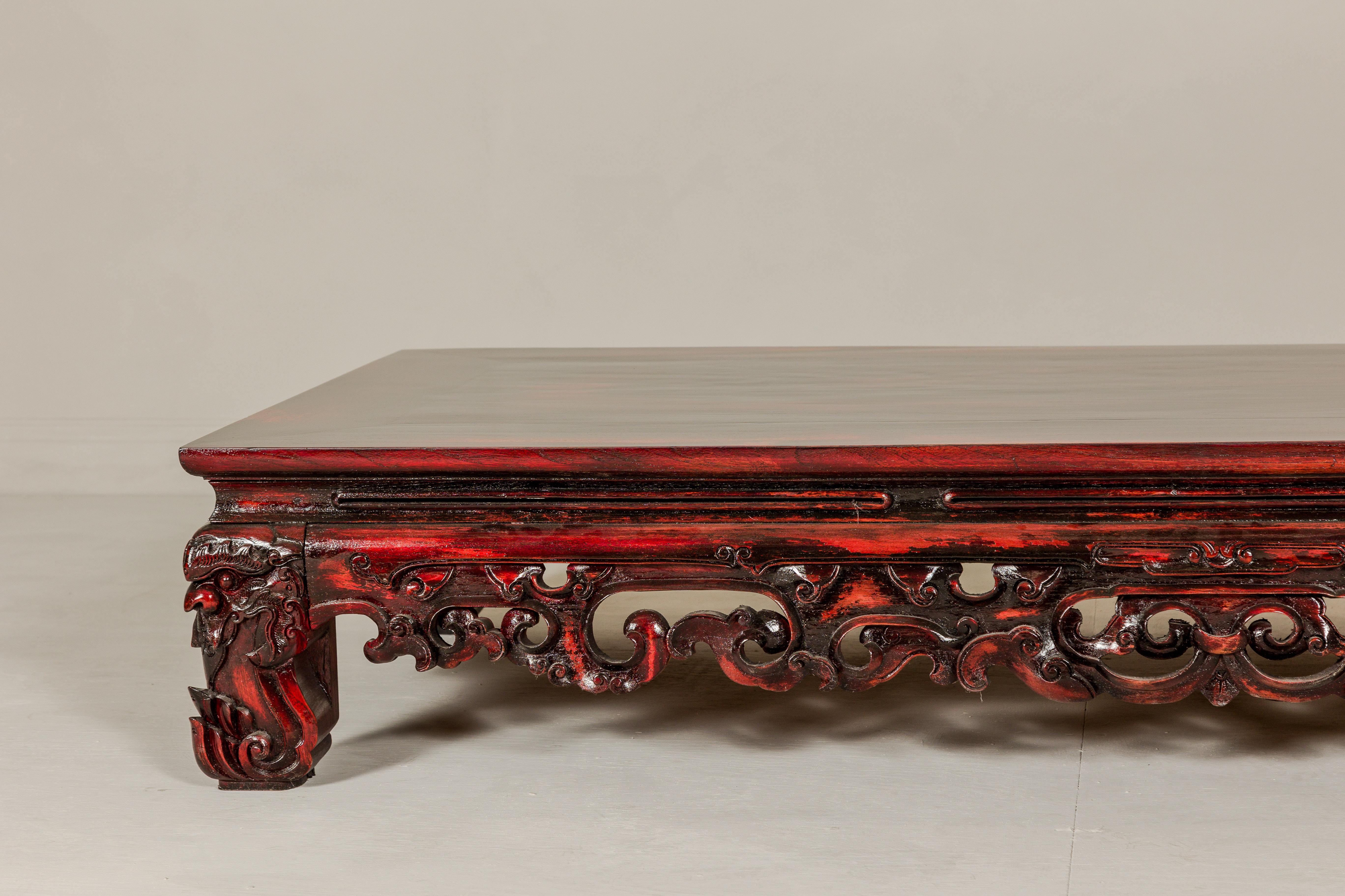 Qing Dynasty Low Kang Coffee Table with Reddish Brown Finish and Carved Décor In Good Condition For Sale In Yonkers, NY