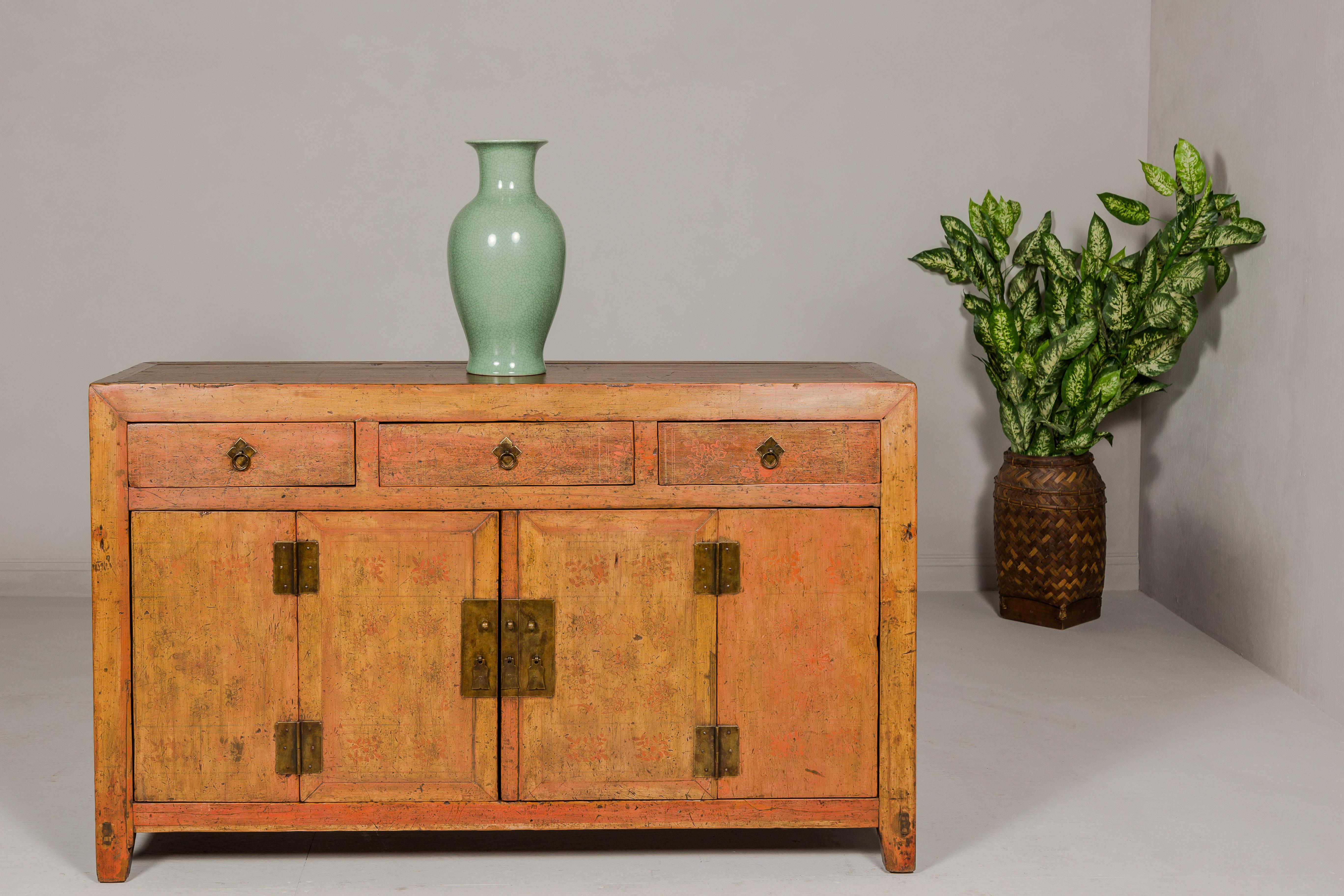 A Qing Dynasty period painted sideboard from the 19th century with distressed patina and three drawers over two doors. This Qing Dynasty period painted sideboard from the 19th century is a remarkable piece of historical furniture, showcasing the