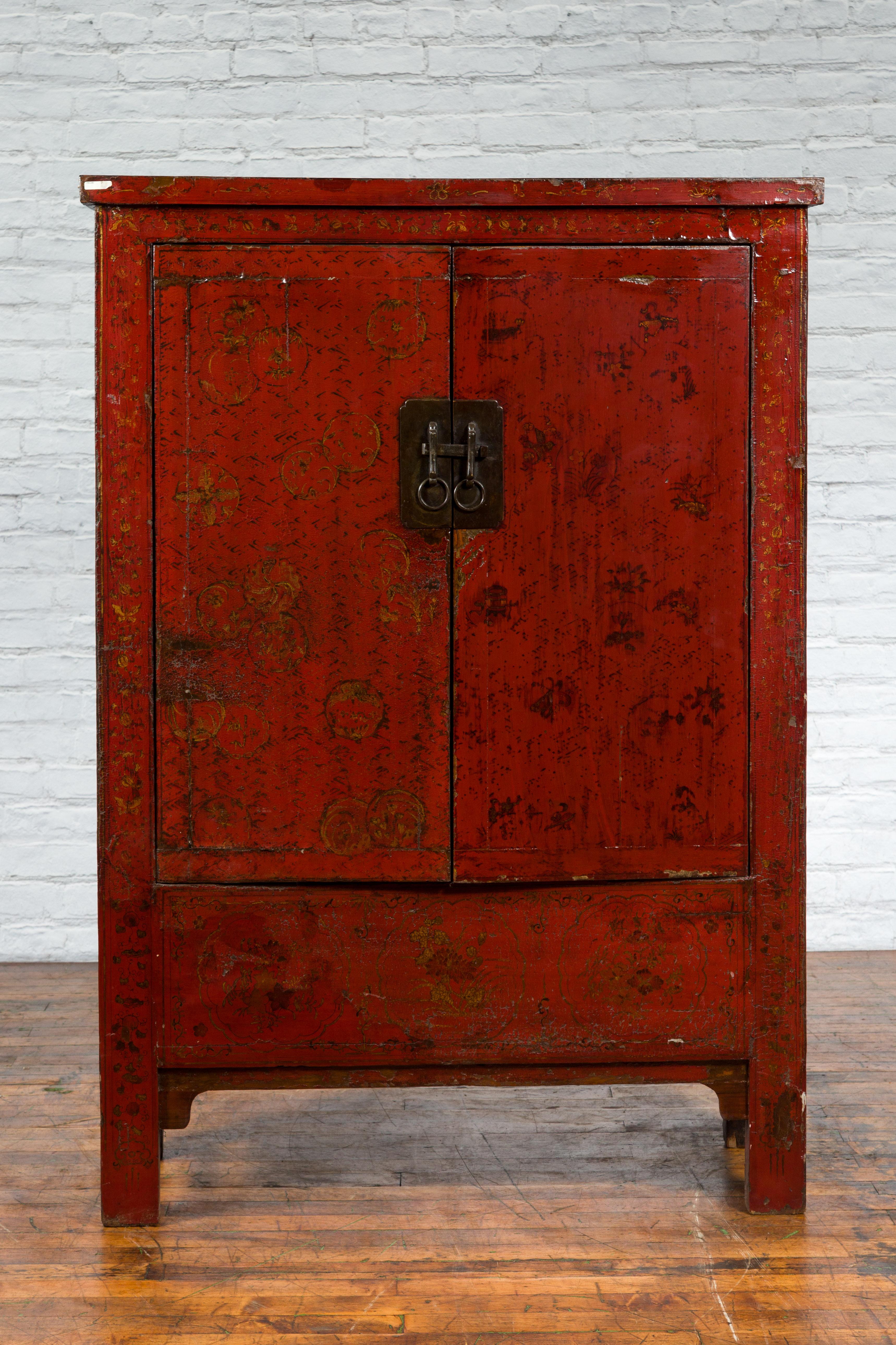 A Chinese Qing Dynasty period Shanxi cabinet from the 19th century with original red lacquer and floral décor. Created in the North-Eastern province of Shanxi during the Qing dynasty, this 19th century cabinet features a linear silhouette perfectly