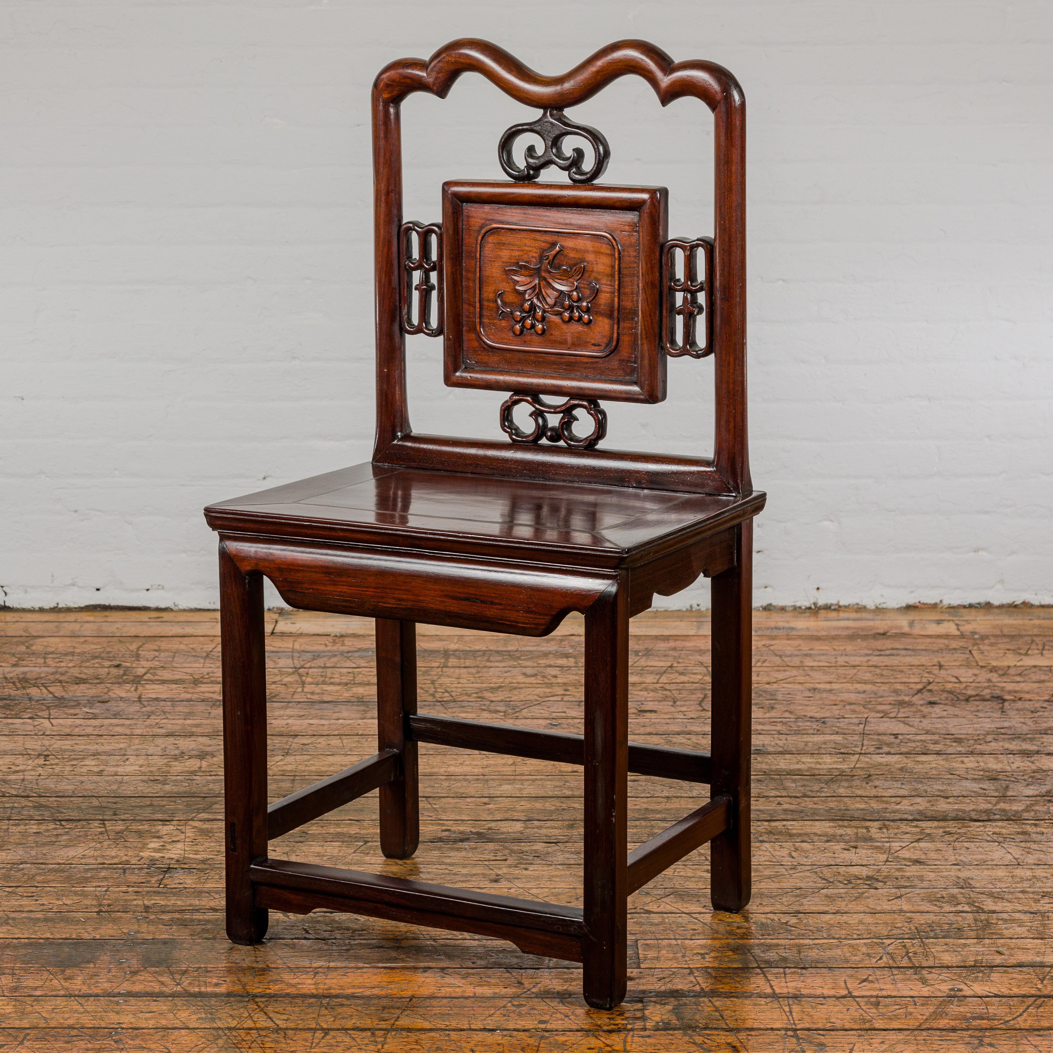 A late Qing Dynasty period rosewood side chair with carved splat adorned with grapevine motif. This late Qing Dynasty rosewood side chair is a stunning testament to the craftsmanship of its era, meticulously restored to its former glory. With a