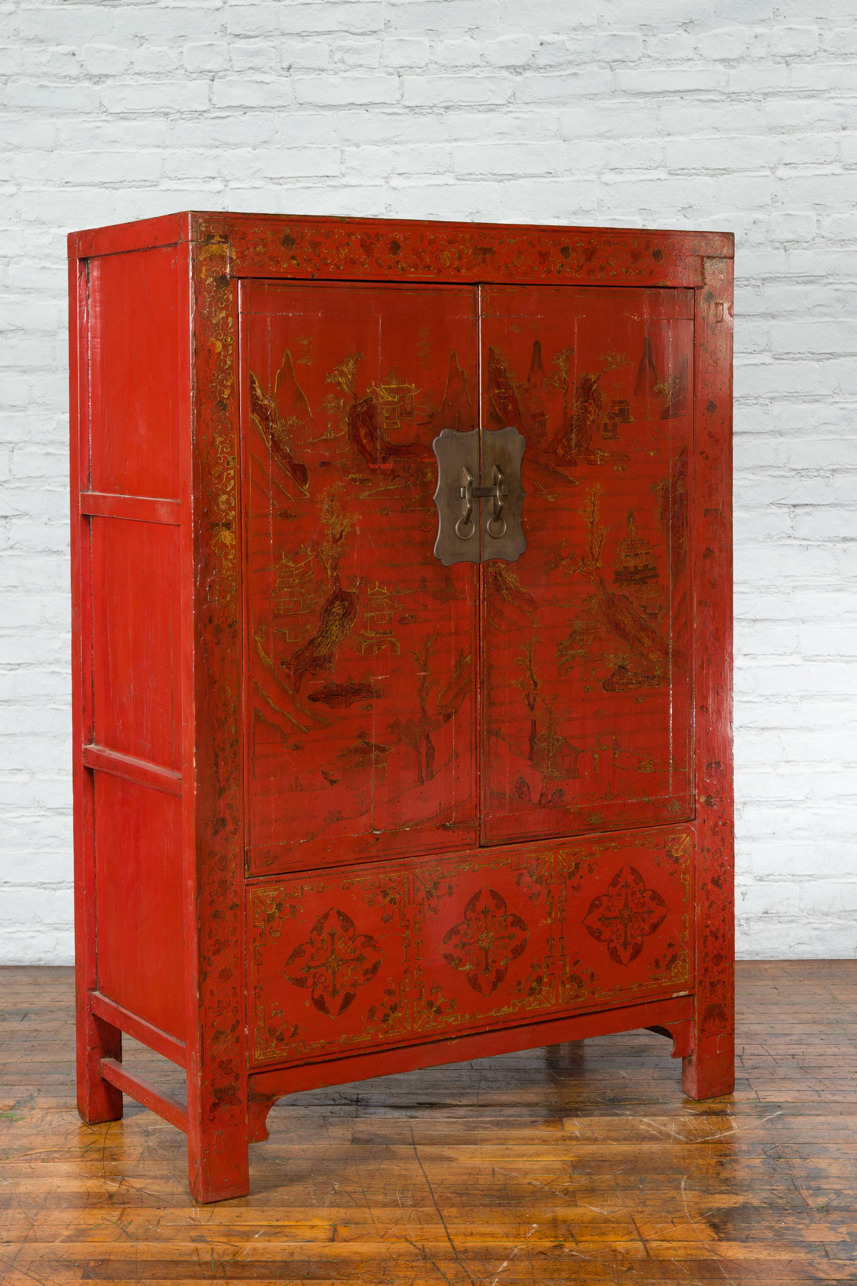 A Chinese Qing Dynasty period red lacquer cabinet from the 19th century, with two doors and hand-painted décor. Created in China during the Qing Dynasty, this cabinet captures our attention with its red lacquer beautifully adorned with a gilded