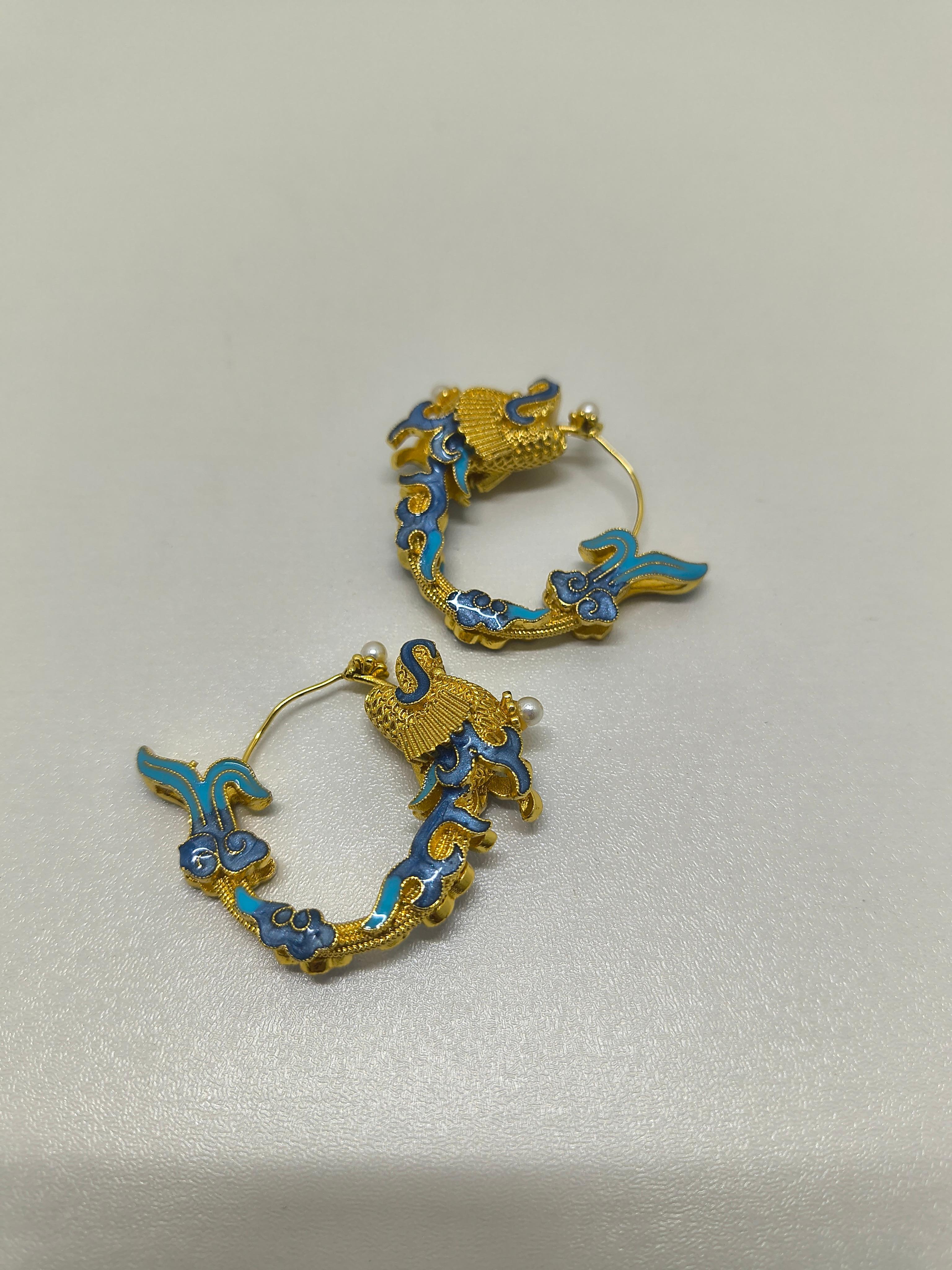 Orecchini a cerchio con drago smaltato in stile dinastia Qing

Ispirati all'opulenza e al simbolismo dell'arte imperiale della dinastia Qing, questi squisiti orecchini sono caratterizzati da un motivo a spirale di drago reso in radioso metallo color