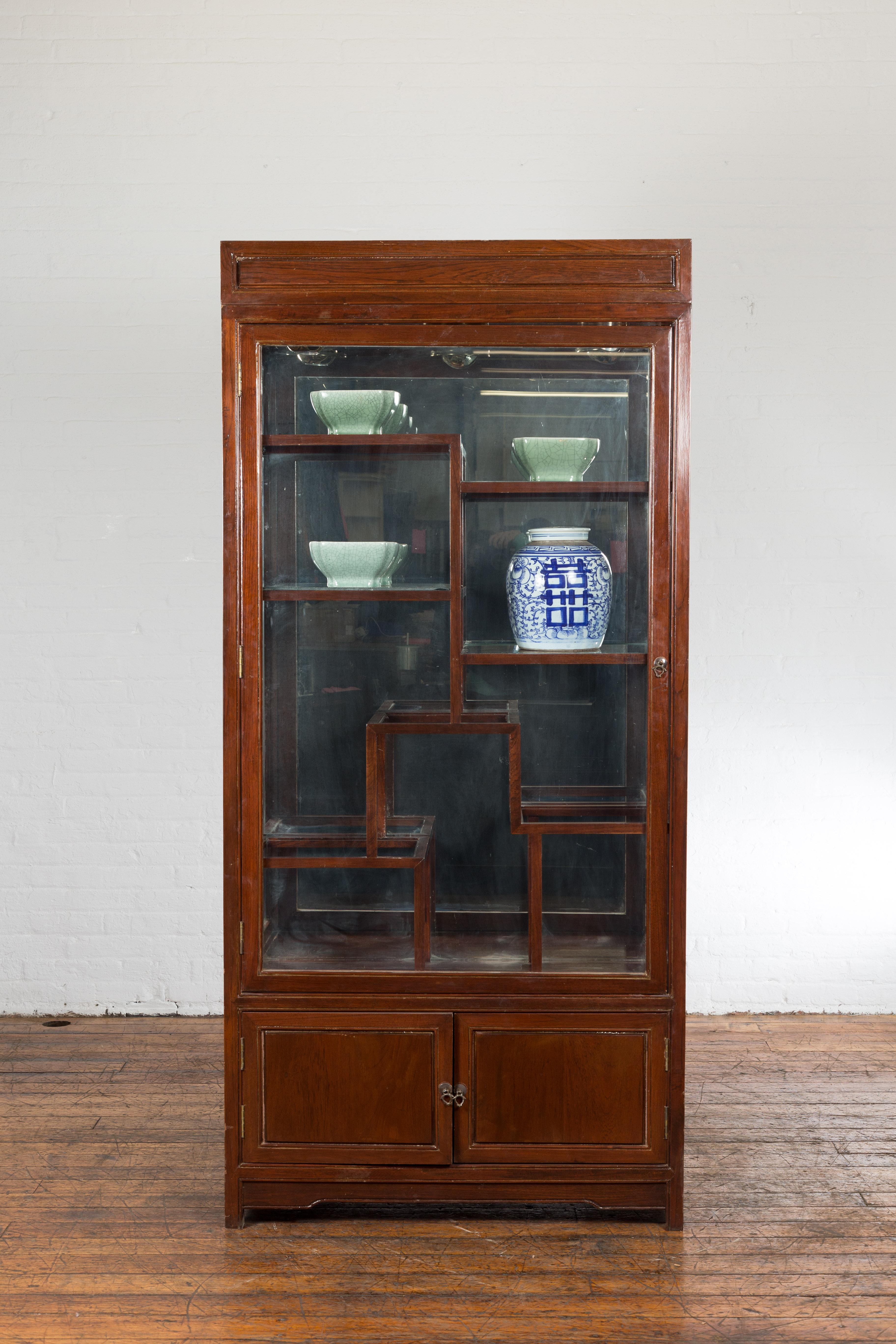 A Qing Dynasty style Thai vitrine cabinet from the late 20th century, with glass as well as wooden doors, retrofitted with glass shelves, spot lights and mirrored wall. This Qing Dynasty style vitrine cabinet from the last quarter of the 20th
