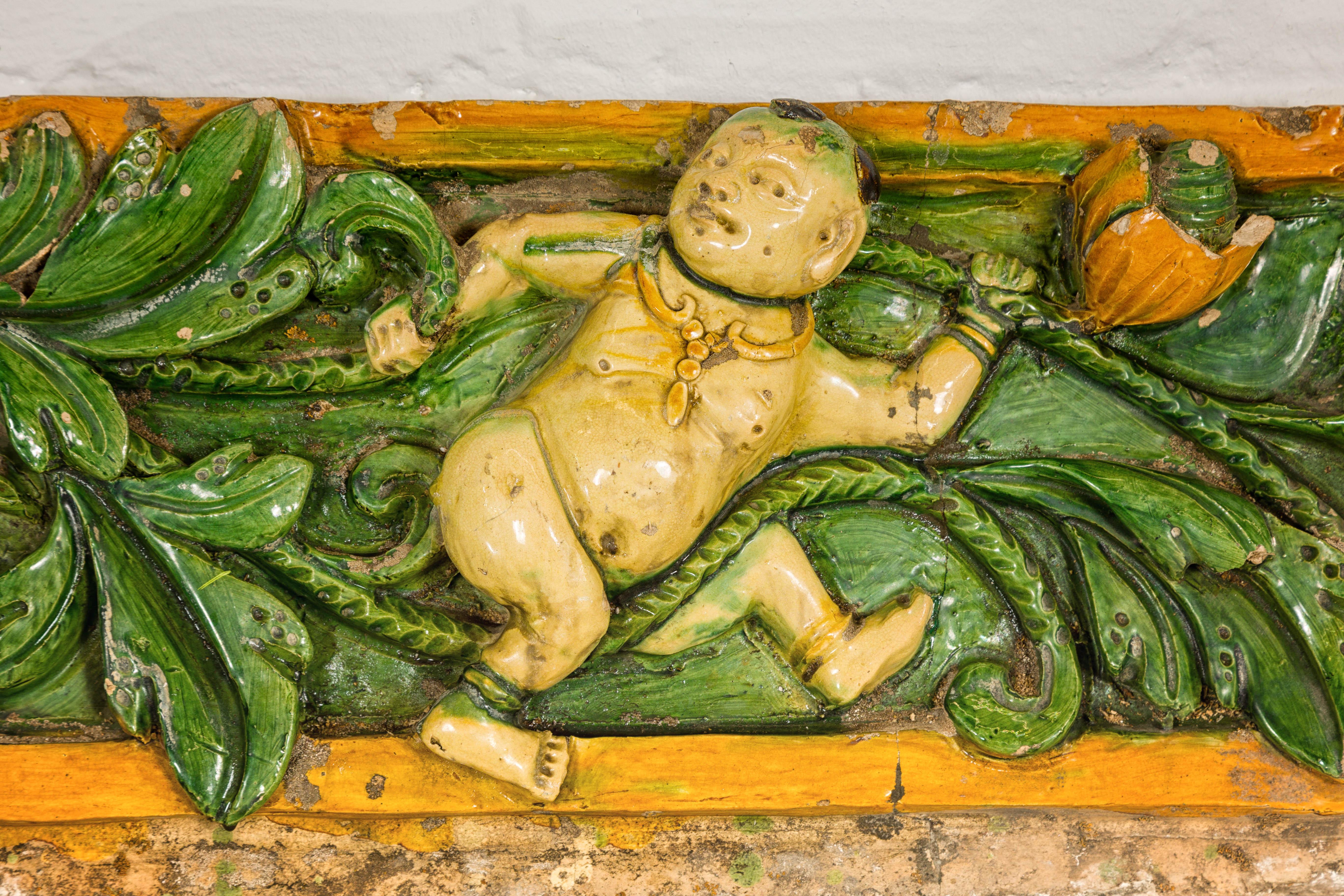 Glazed Qing Dynasty Tricolor Raised Relief Roof Fragment from Temple with Boy in Leaves For Sale