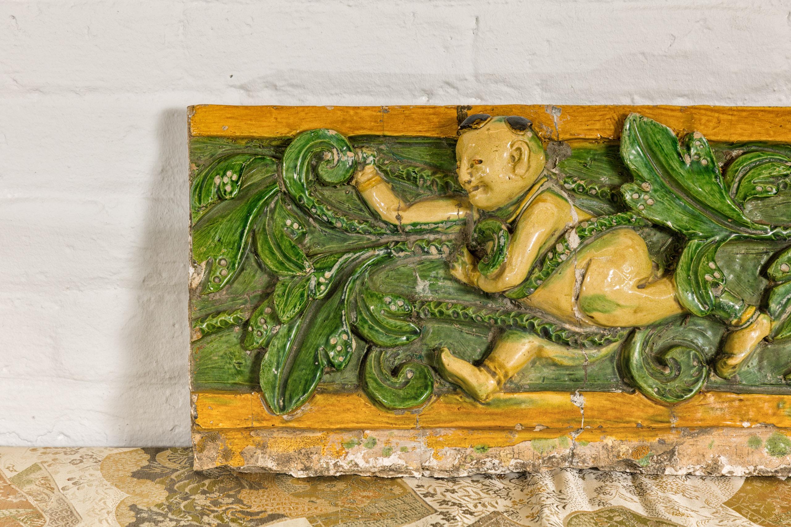 Chinese Qing Dynasty Tricolor Roof Fragment from a Temple Depicting a Boy Amidst Leaves For Sale