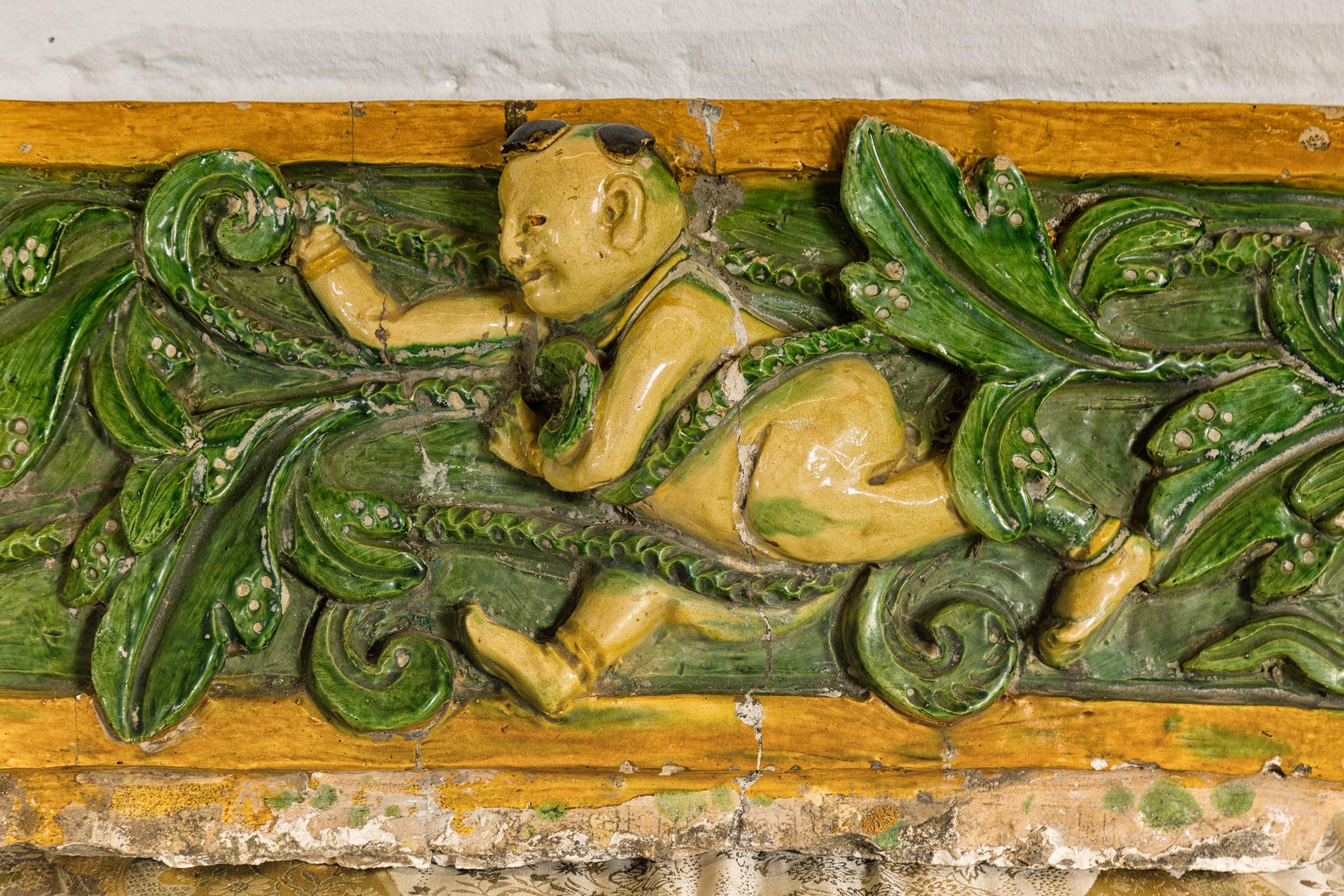 Qing Dynasty Tricolor Roof Fragment from a Temple Depicting a Boy Amidst Leaves In Good Condition For Sale In Yonkers, NY