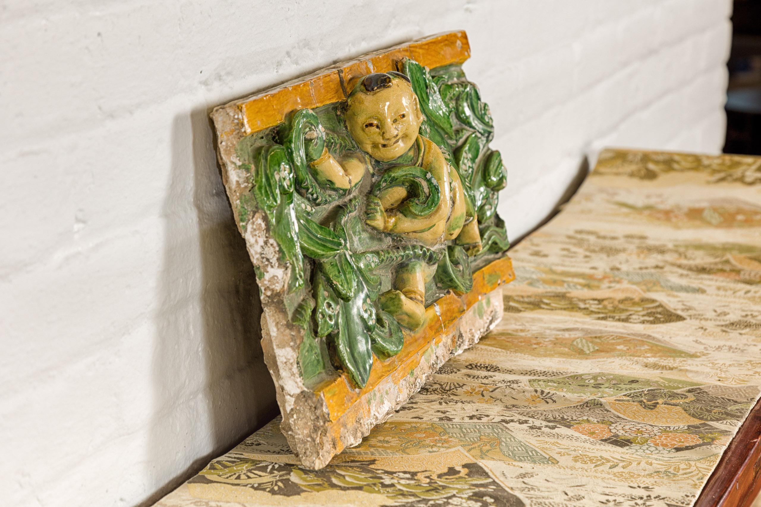 19th Century Qing Dynasty Tricolor Roof Fragment from a Temple Depicting a Boy Amidst Leaves For Sale