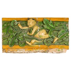 Fragment de toit tricolore de la dynastie Qing représentant un garçon au milieu de feuilles