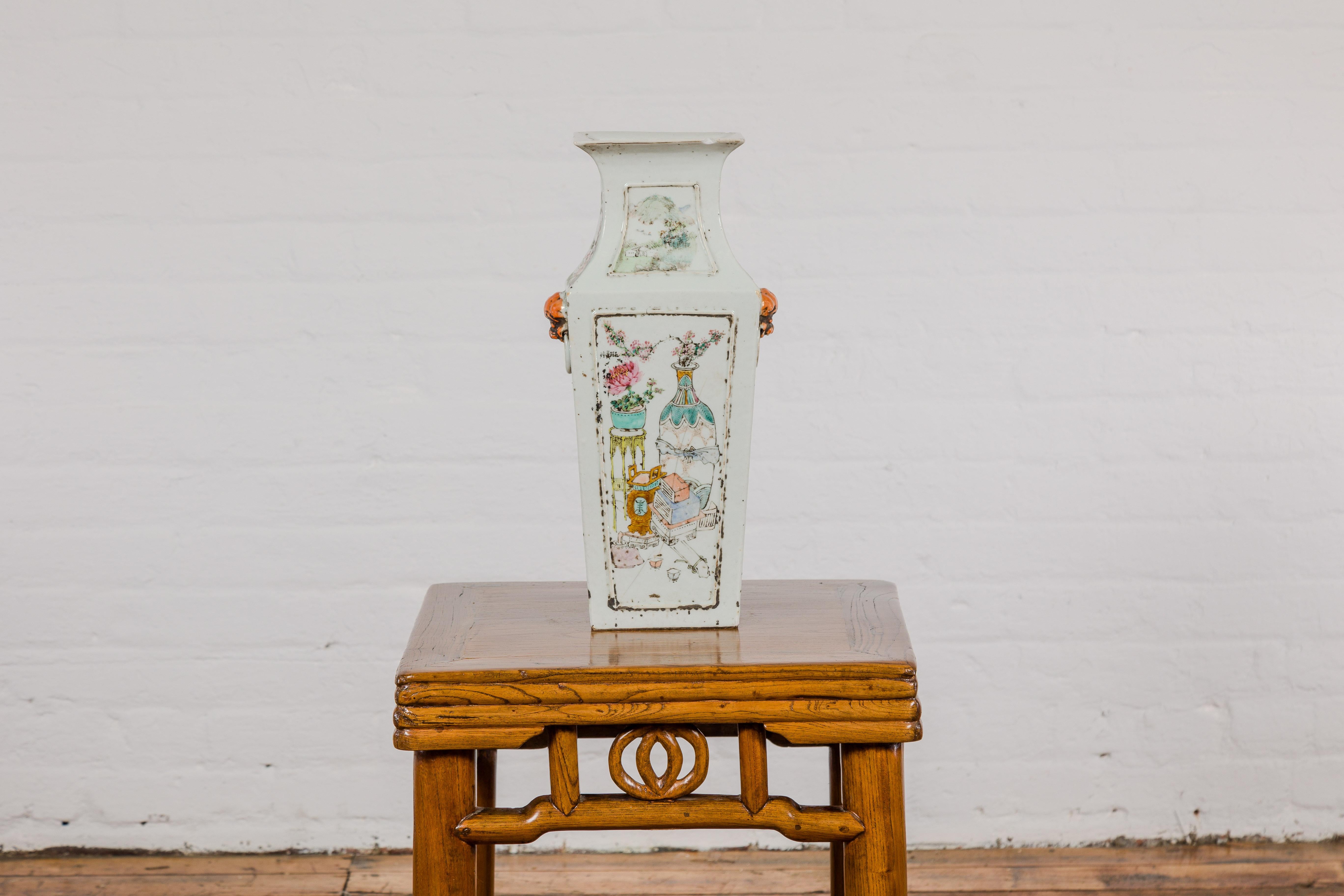 A Chinese Qing Dynasty period white porcelain vase with painted flowers, objects and calligraphy. This exquisite Chinese Qing Dynasty period white porcelain vase is a remarkable specimen of the era's unparalleled porcelain artistry. The vase is