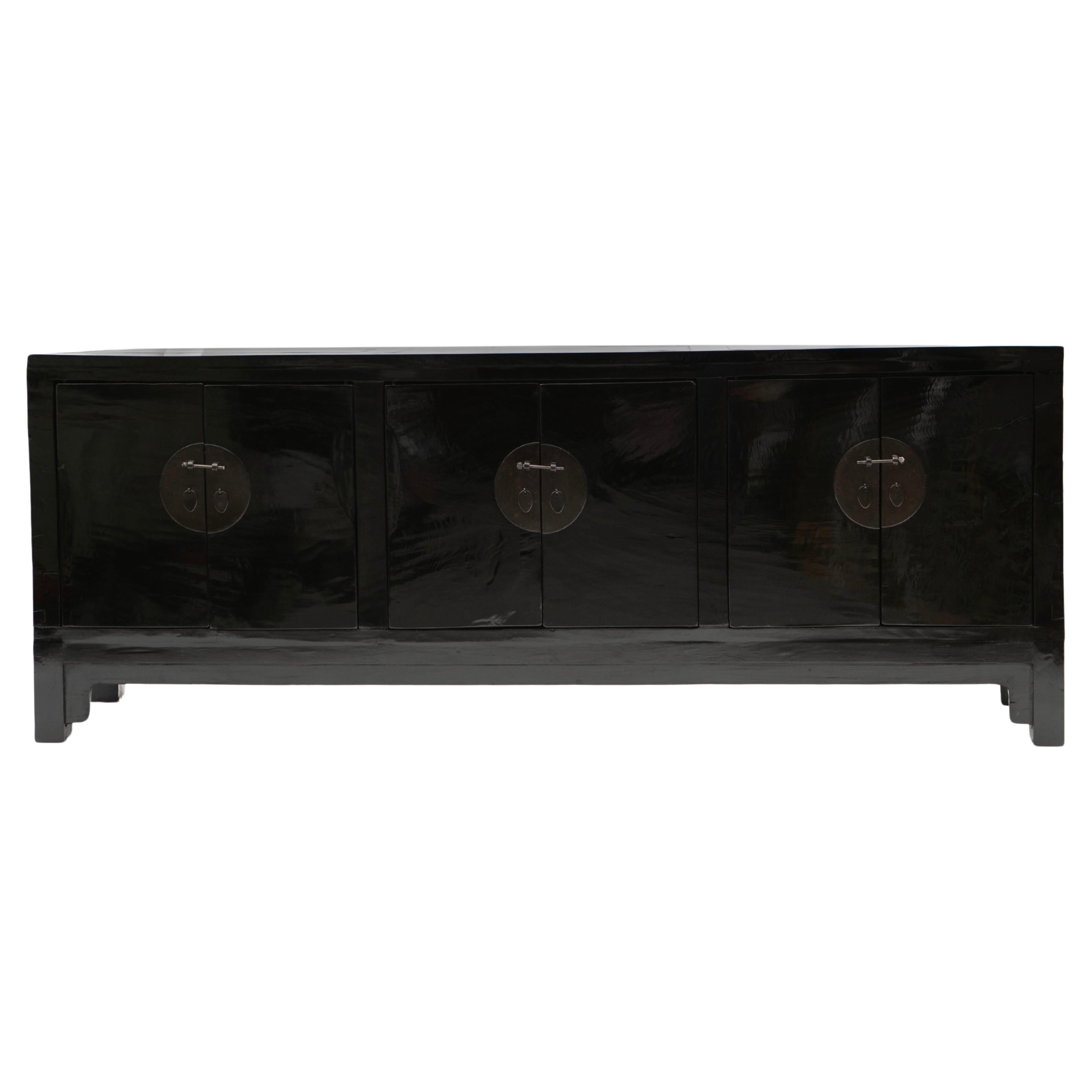 An antique Chinese black lacquer sideboard from the Qing period.

Crafted in black polished walnut and featuring 3 pairs of doors adorned with round metal fittings. The interior offers removable shelves for customizable storage.

Originating from