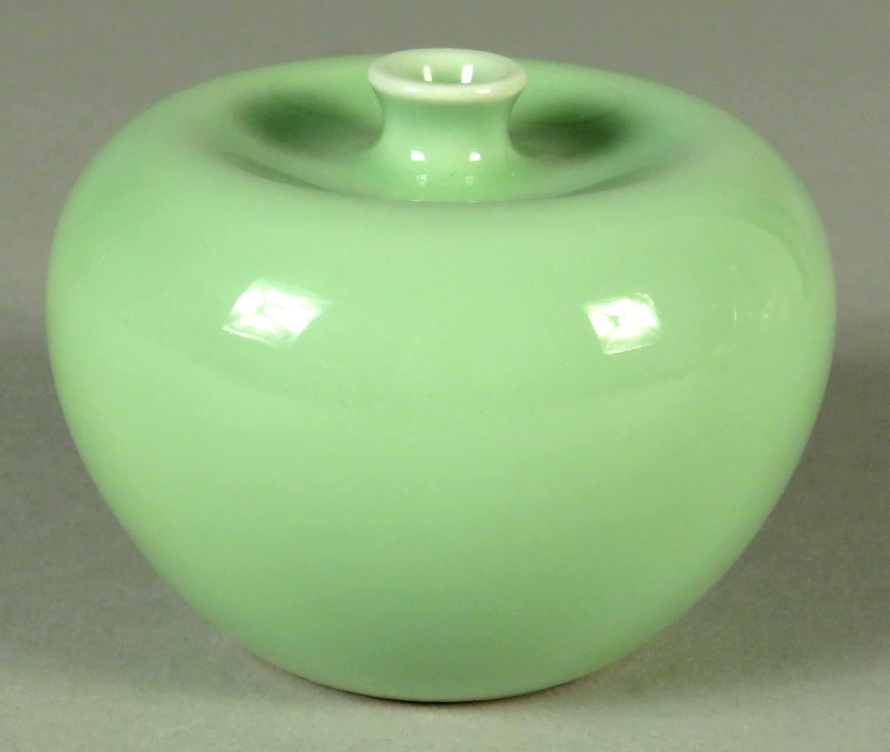 The body of compressed globular form having a short flaring neck rising from a shallow indenture and exhibiting a fine celadon glaze overall. The base showing six-character under-glaze blue marks for Guangxu Period (1871-1908).


 