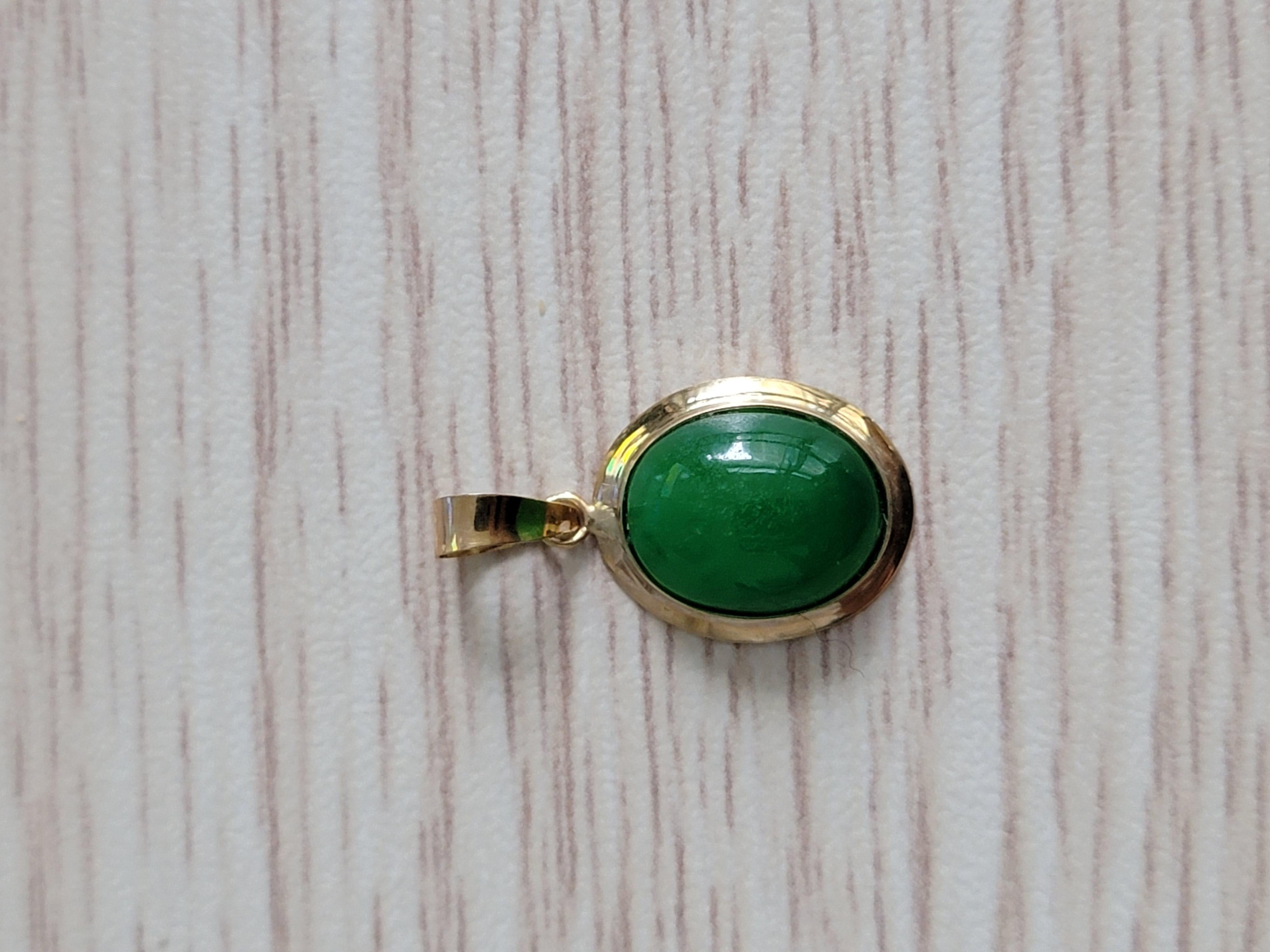 Drop and Dangle Jadeite Pendant with solid 14K Yellow Gold. Jadeite Cabochon engulfed in 14K Yellow Gold Circumference and chain hook. 

‘The Qīng Zhong Jade Pendant’ represent nature’s colors in Mandarin and means clear or pure. Its the medium