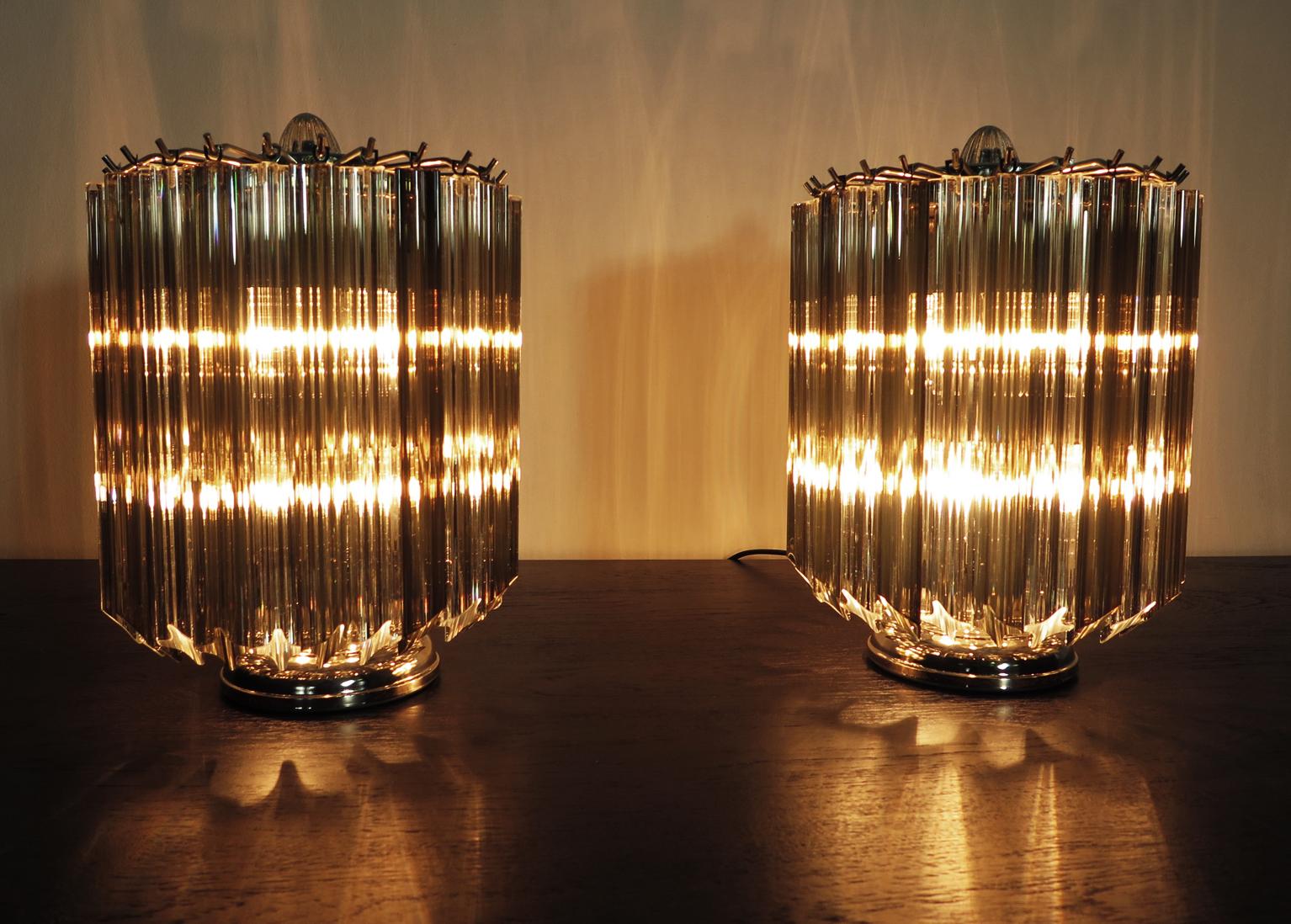 Prächtiges Paar Tischlampen, 24 trasparente und geräucherte Quadriedri für jede Lampe. Elegantes Möbelstück.
Zeitraum: Ende des XX. Jahrhunderts
Abmessungen: 15 Zoll (38 cm) Höhe; 10,50 Zoll (27 cm) Durchmesser.
Dimension Brille:  11 Zoll (28 cm)