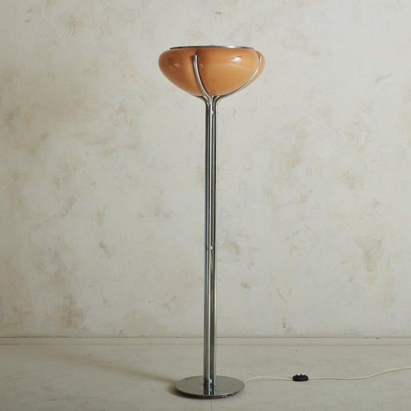 A Quadrifoglio floor lamp designed by Gae Aulenti for Harvey Guzzini in 1974. This striking lamp features a molded acrylic shade in a beautiful cognac hue. It has a polished chrome circular base and four tubular chrome stems, which support the